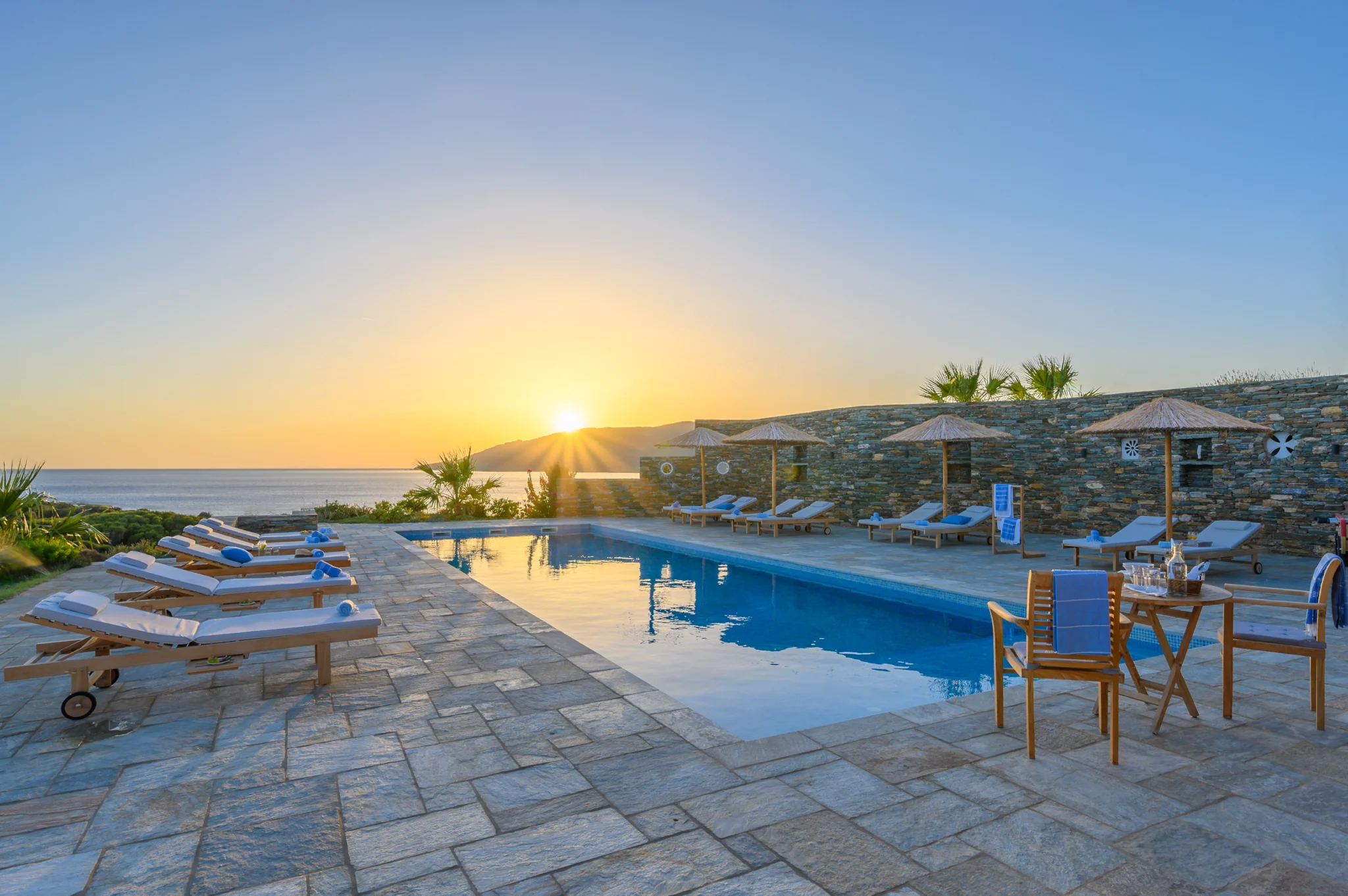 Villa Golden Beach — Pool at sunset, Andros Low evening sun over the sea reflected in the swimming pool at Villa Golden Beach in Andros