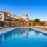Swimming pool reflecting the evening sky below the white and stone buildings at Villa Golden Beach in Andros, Greece