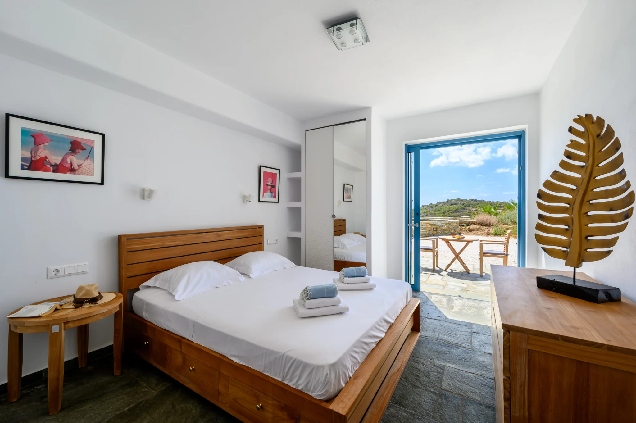 Villa Golden Beach — Bedroom with blue balcony door, Andros Bedroom with a timber headboard and blue glazed balcony door at Villa Golden Beach in Andros