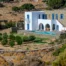 Villa Thalassa with white arches, stone walls and a pool above an olive grove in Andros, Greece