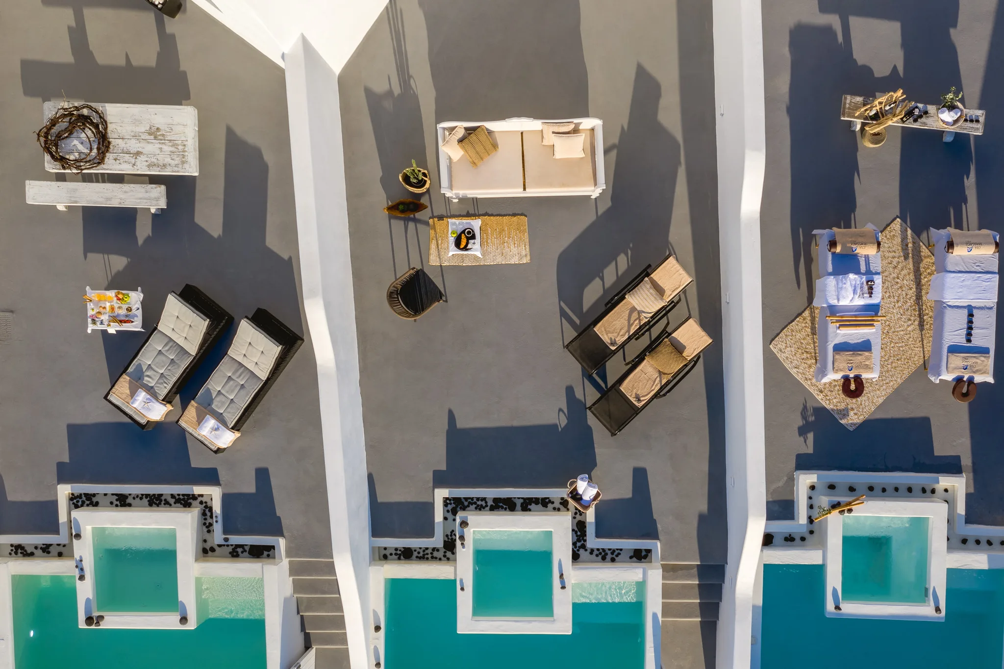 Direct aerial view of rooftop terraces, loungers and small pools