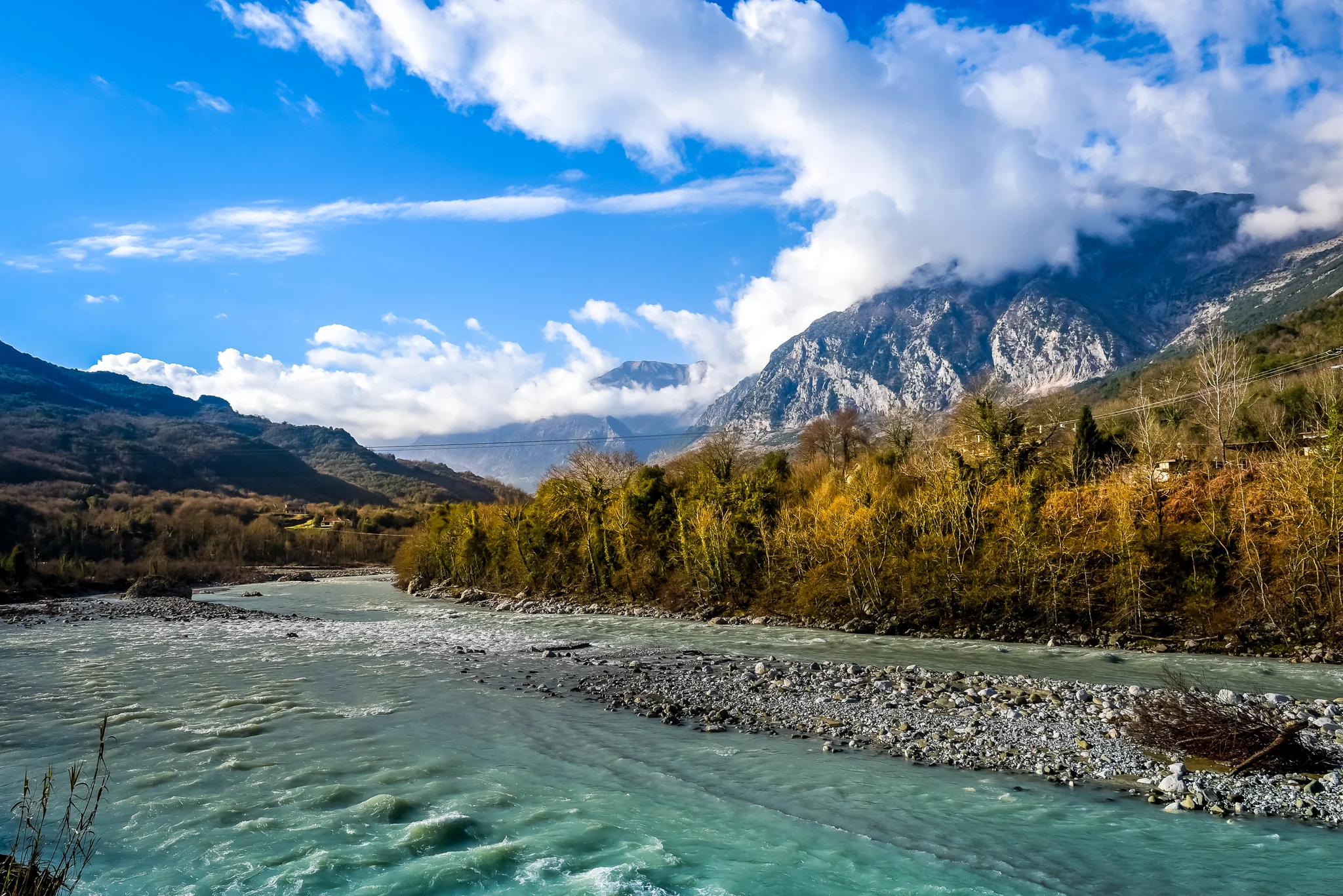 Fast pale-blue river crossing a broad mountain valley