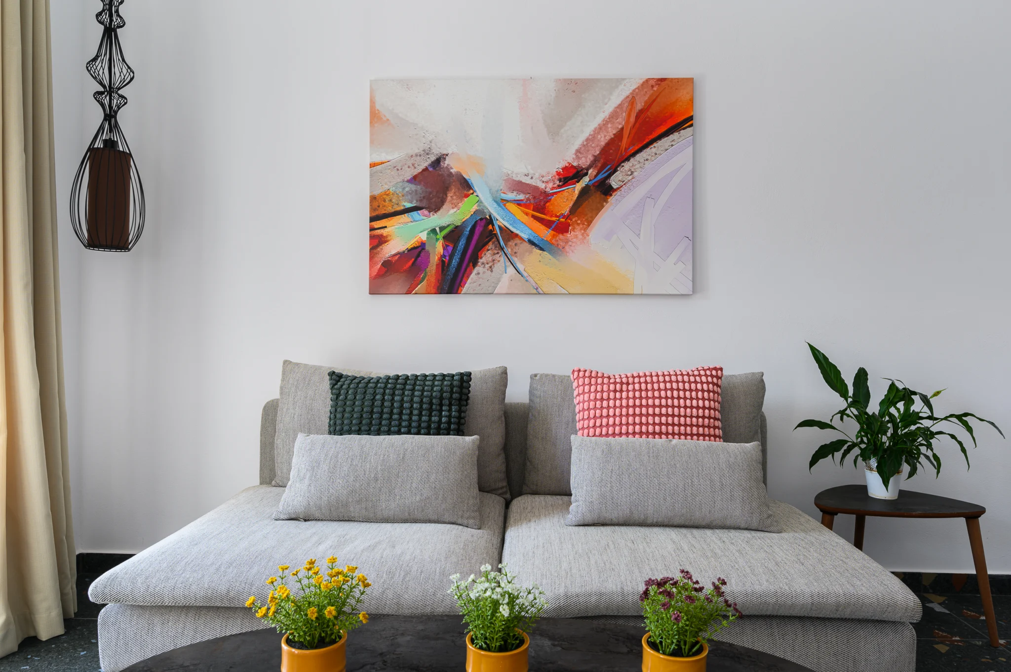 Grey sofa with cushions and colourful artwork at Blue Sky House, Pylos, Peloponnese, Greece.