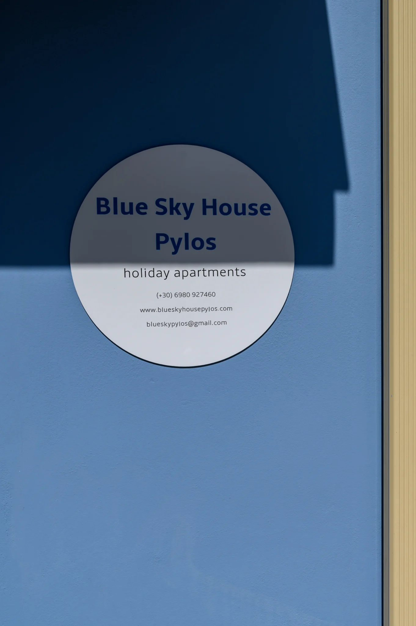 Blue Sky House sign on a blue exterior wall at Blue Sky House, Pylos, Peloponnese, Greece.