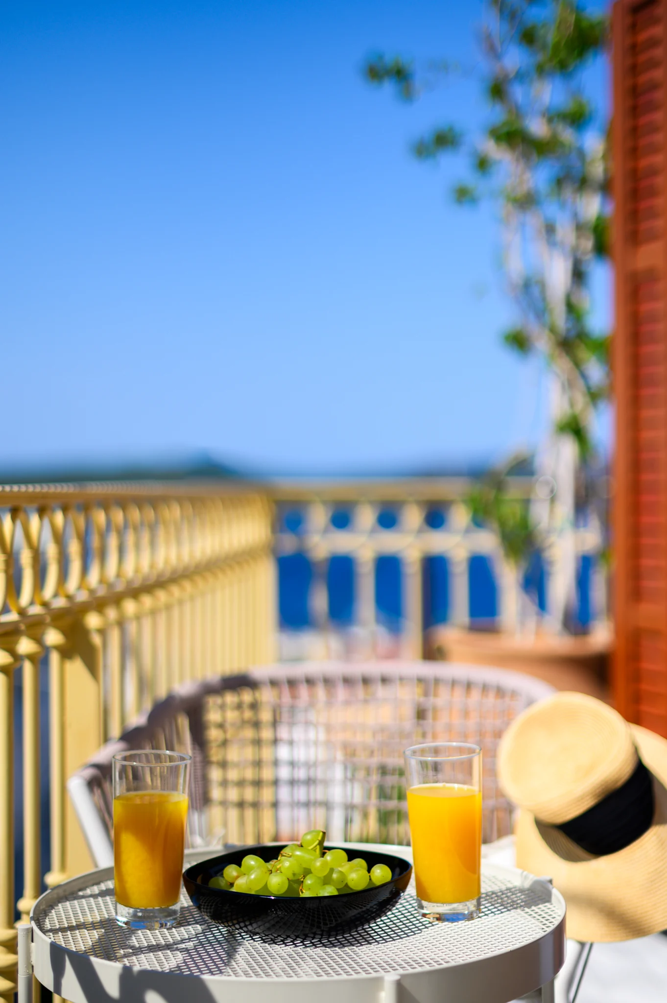 Breakfast table with orange juice on a balcony overlooking the sea at Blue Sky House, Pylos, Peloponnese, Greece.