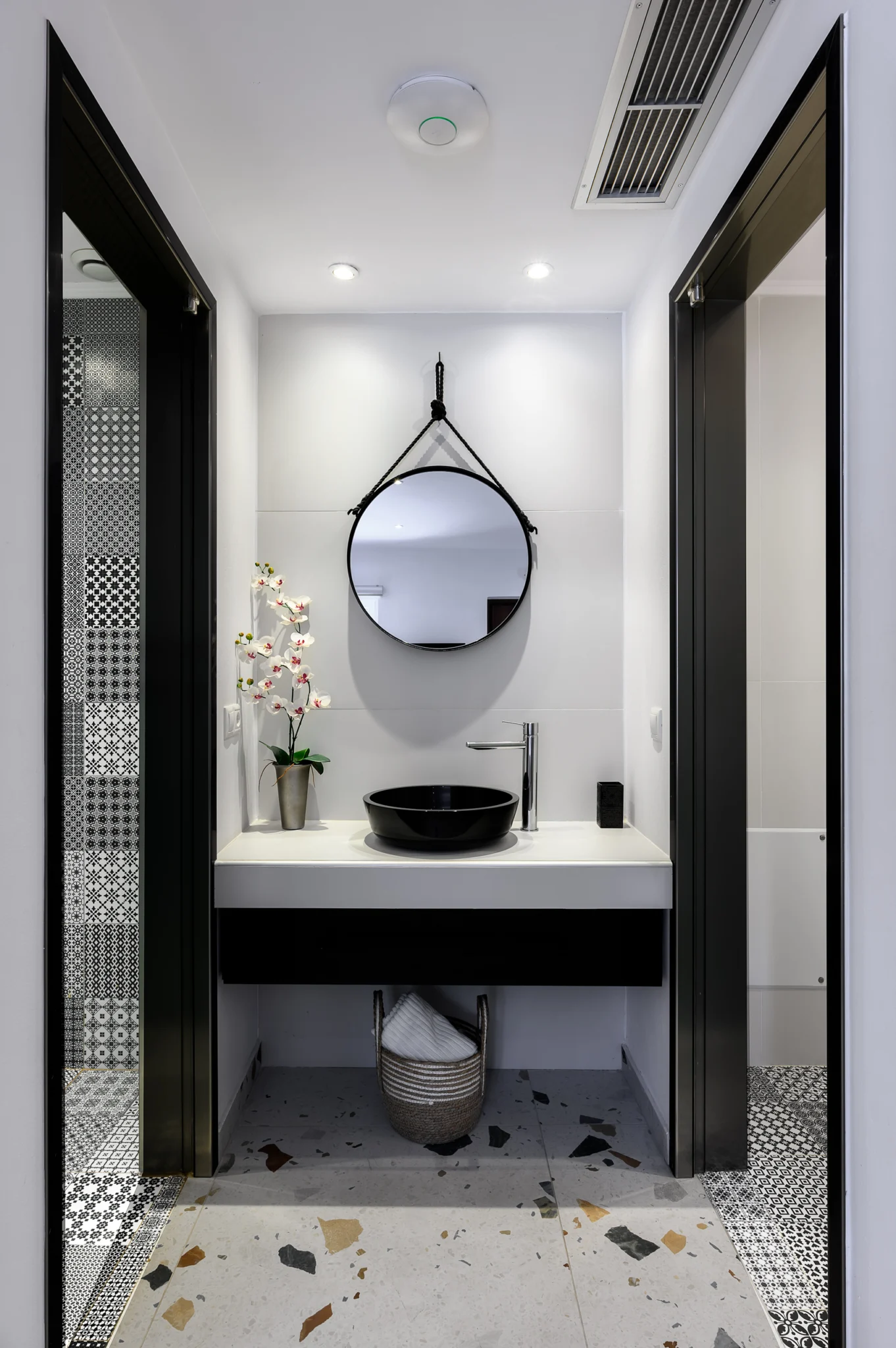 Bathroom vanity with a round mirror and black basin at Blue Sky House, Pylos, Peloponnese, Greece.