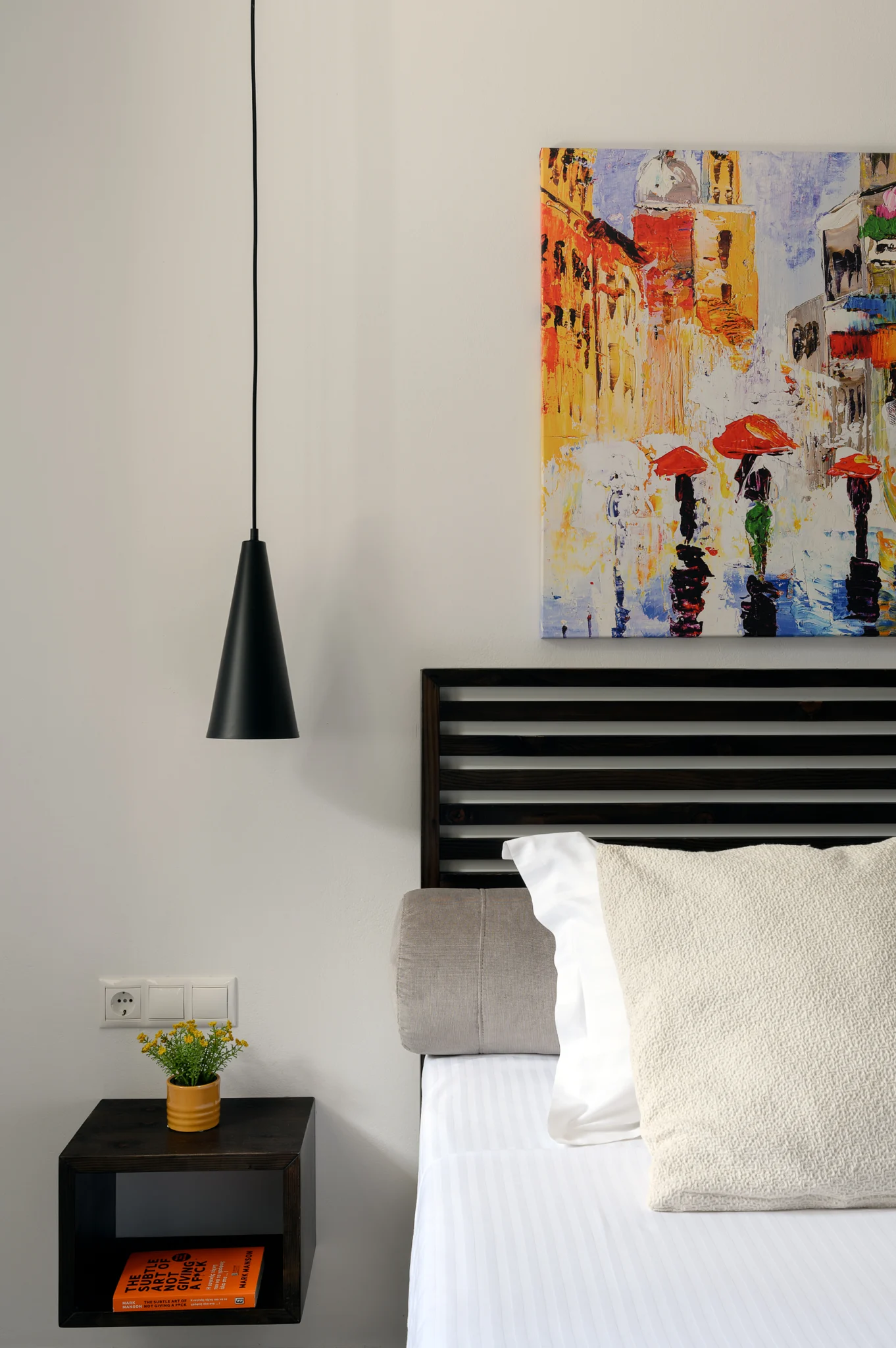Bedside detail with a pendant light and colourful artwork at Blue Sky House, Pylos, Peloponnese, Greece.