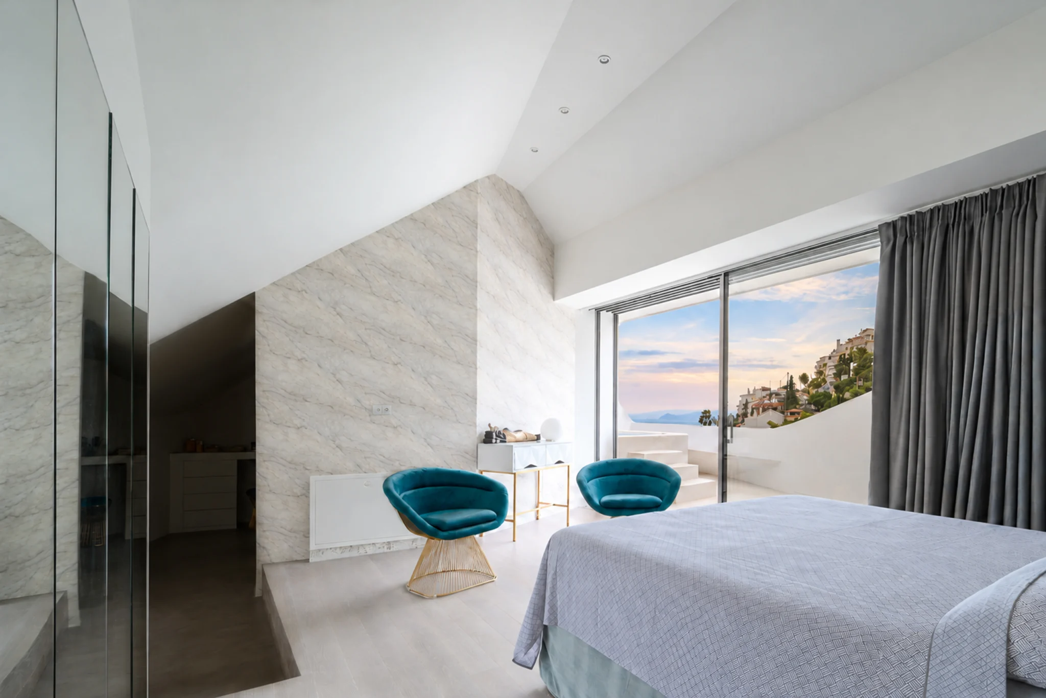 Bedroom with teal chairs, a glazed wall and a terrace view at Contemporary Minimalistic Villa, Athens, Attica, Greece.