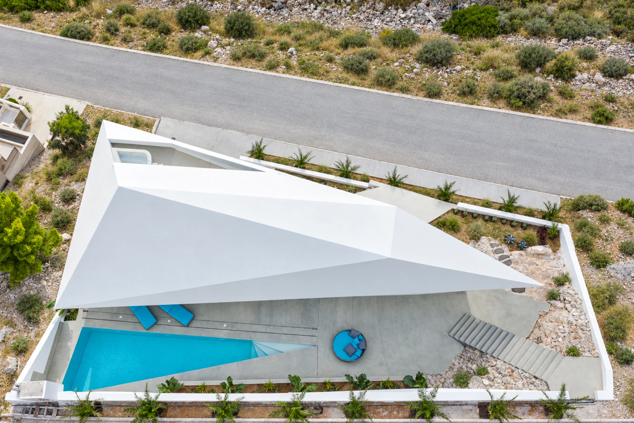 Overhead view of the white roof, courtyard pool and entrance road at Contemporary Minimalistic Villa, Athens, Attica, Greece.