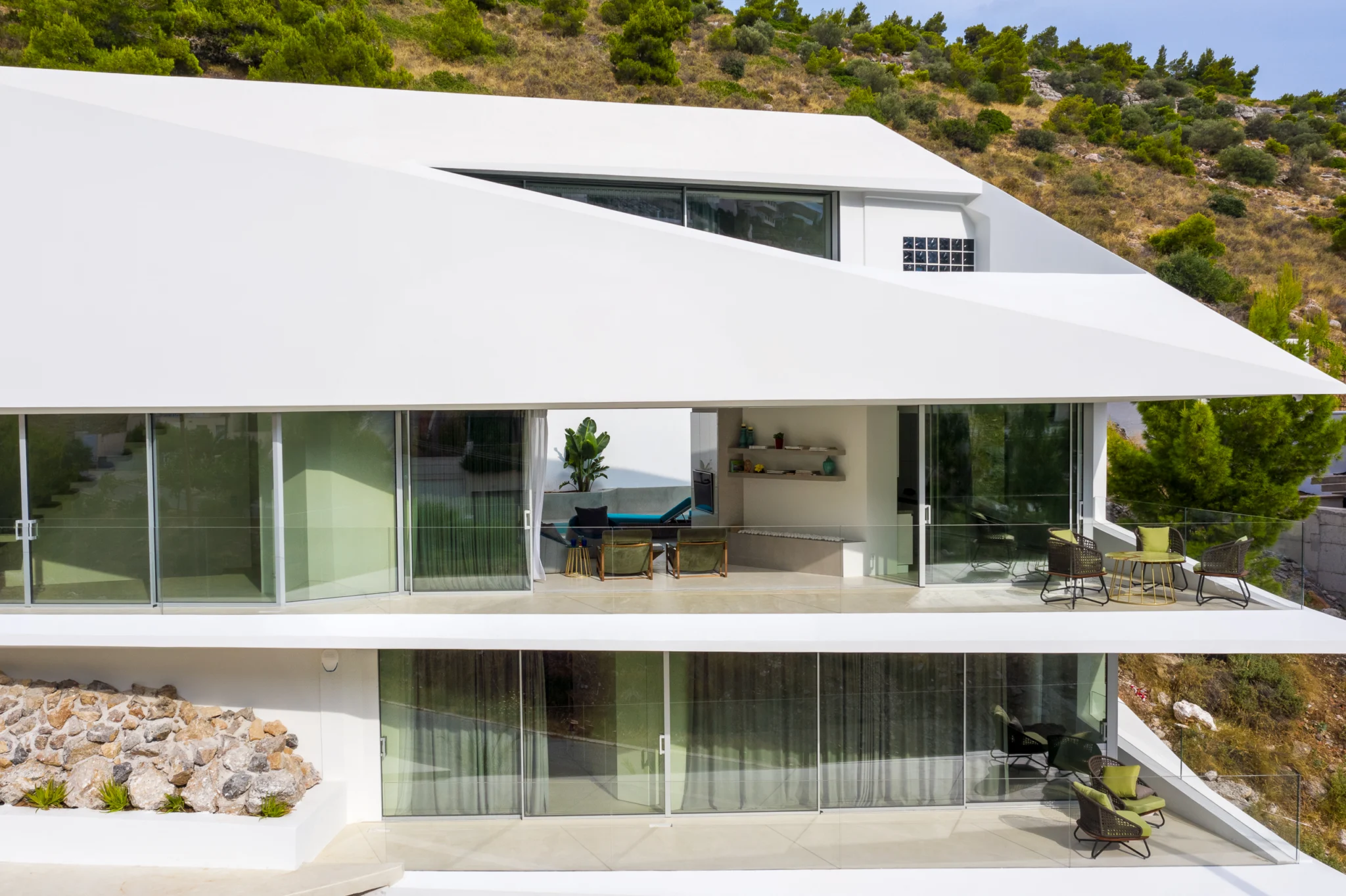 Aerial view of the angular white facade and long glazed frontage at Contemporary Minimalistic Villa, Athens, Attica, Greece.