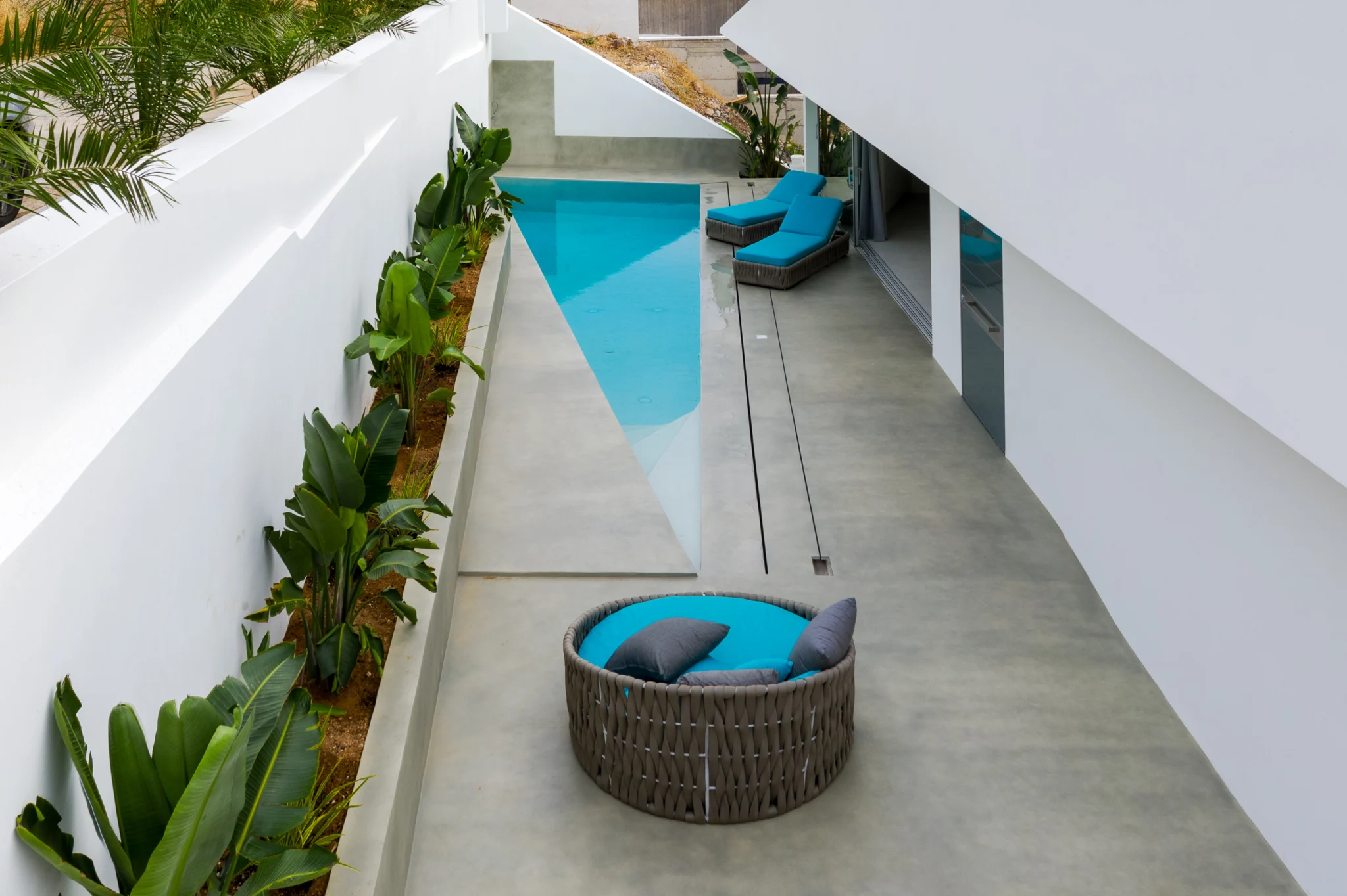 Courtyard pool with planting and a circular outdoor seat at Contemporary Minimalistic Villa, Athens, Attica, Greece.