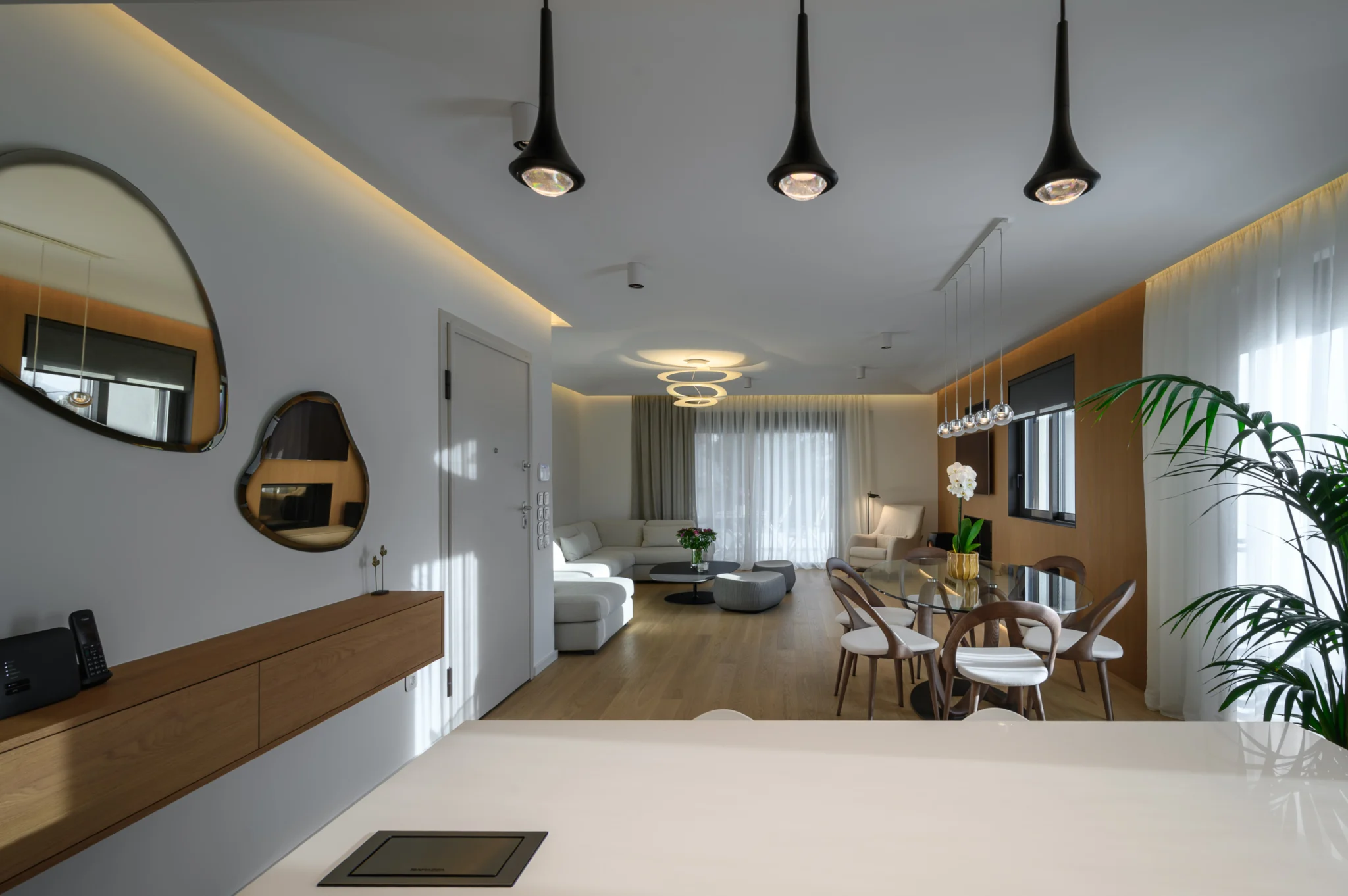 View from the kitchen island towards the dining table and living room in a luxury apartment in northern Athens.
