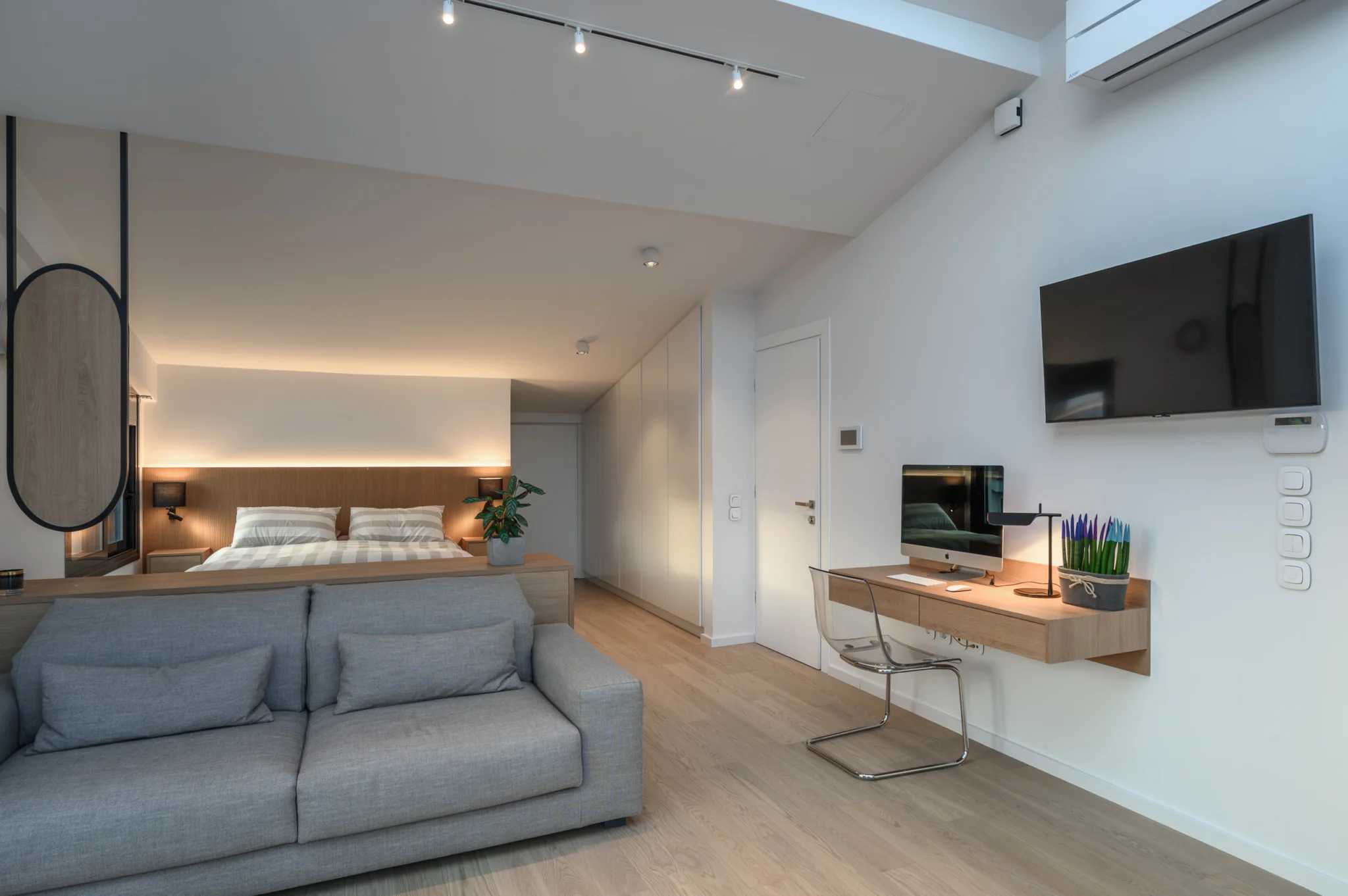 FOUNTIS apartment, Northern Athens — Bedroom and work area with illuminated timber headboard and desk lamp Bedroom and work area with illuminated timber headboard and desk lamp in a luxury apartment in northern Athens.