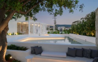 From Arrival to Twilight: The Essential Photography Shot List for Hotels and Villas in Greece 3 White hospitality terrace with built-in seating and an olive tree