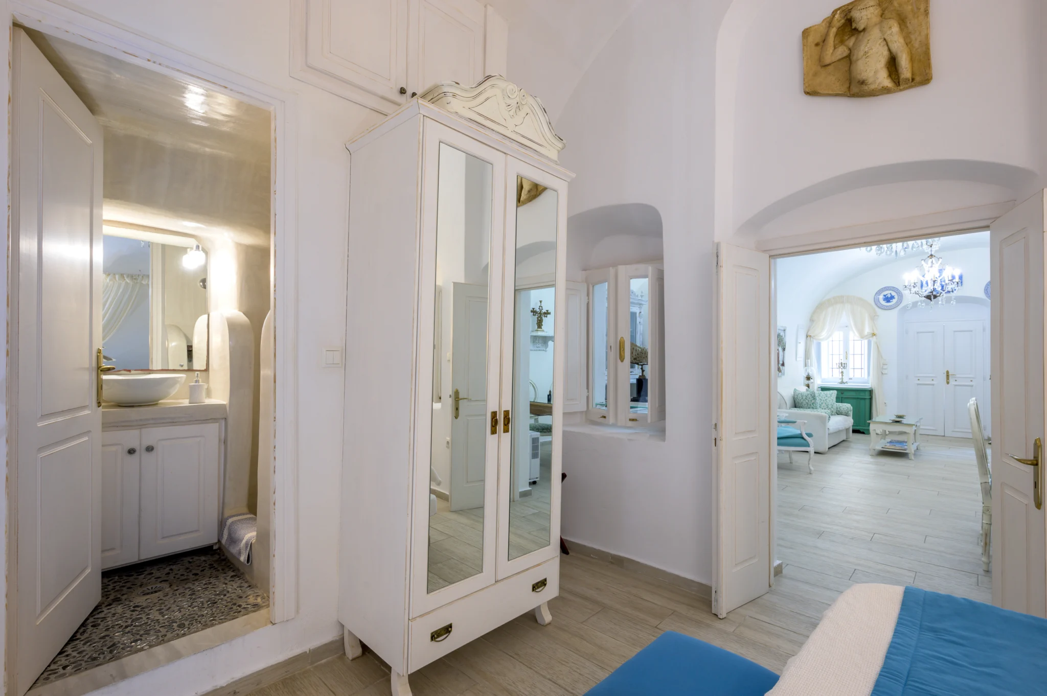Intermezzo, Santorini — Bedroom with a mirrored wardrobe and views towards the bathroom and living area Bedroom with a mirrored wardrobe and views towards the bathroom and living area at Intermezzo in Santorini.