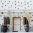 Front entrance with white pergola, flowing curtains and two large dark decorative pots at Intermezzo in Santorini.
