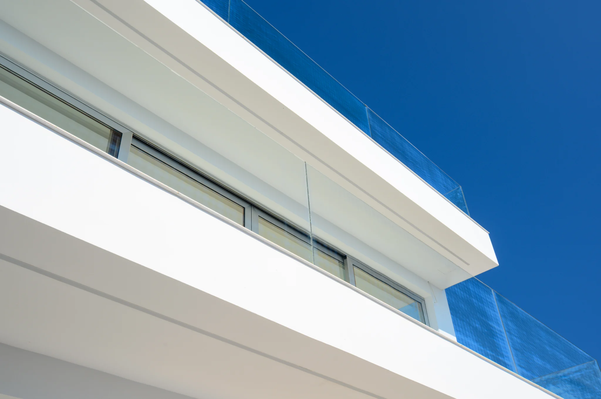 White balcony edges and a glass balustrade against a blue sky at Luxury Residence Blackstone.