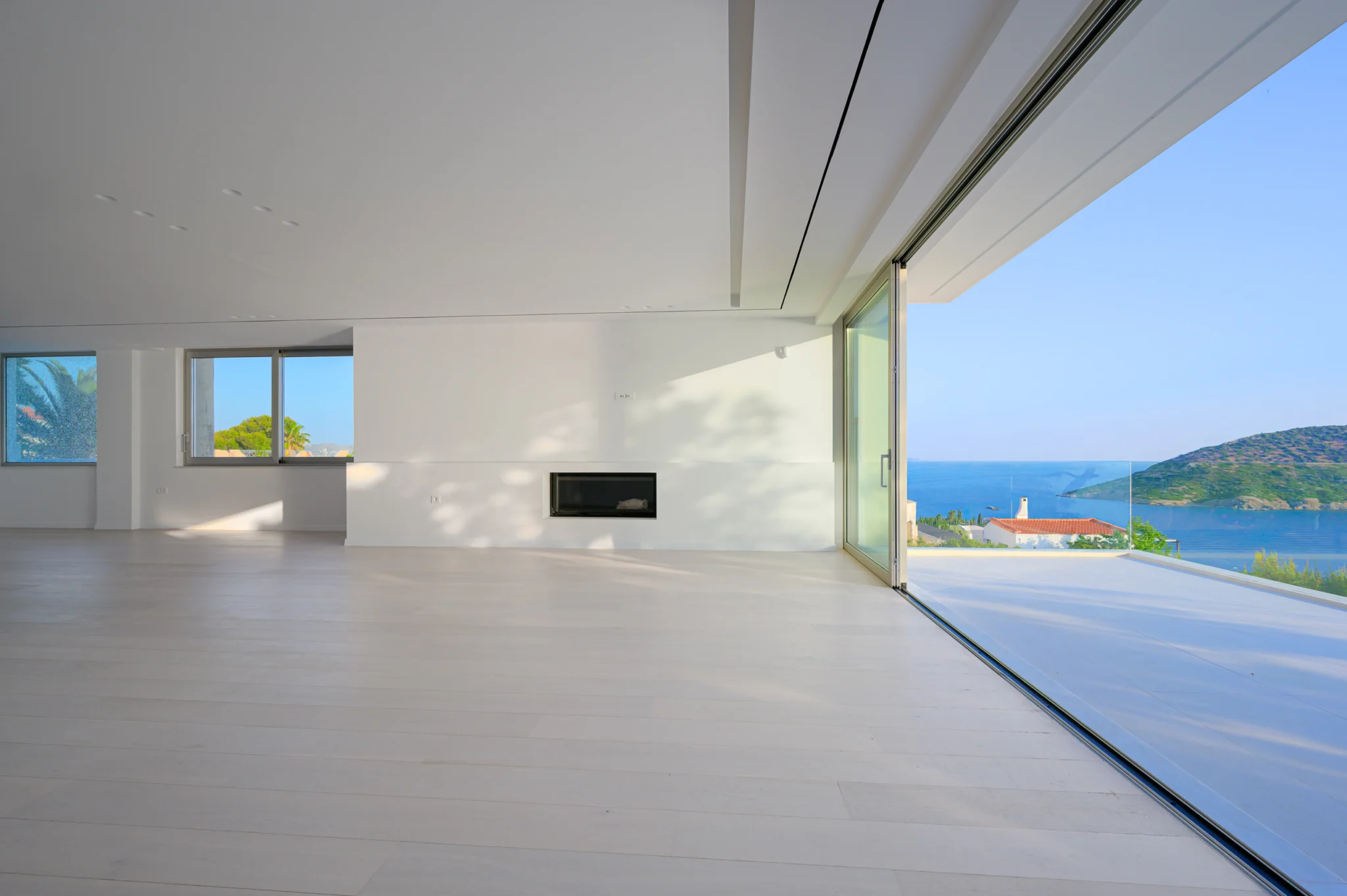 Open living area with a recessed fireplace and coastal views at Luxury Residence Blackstone.