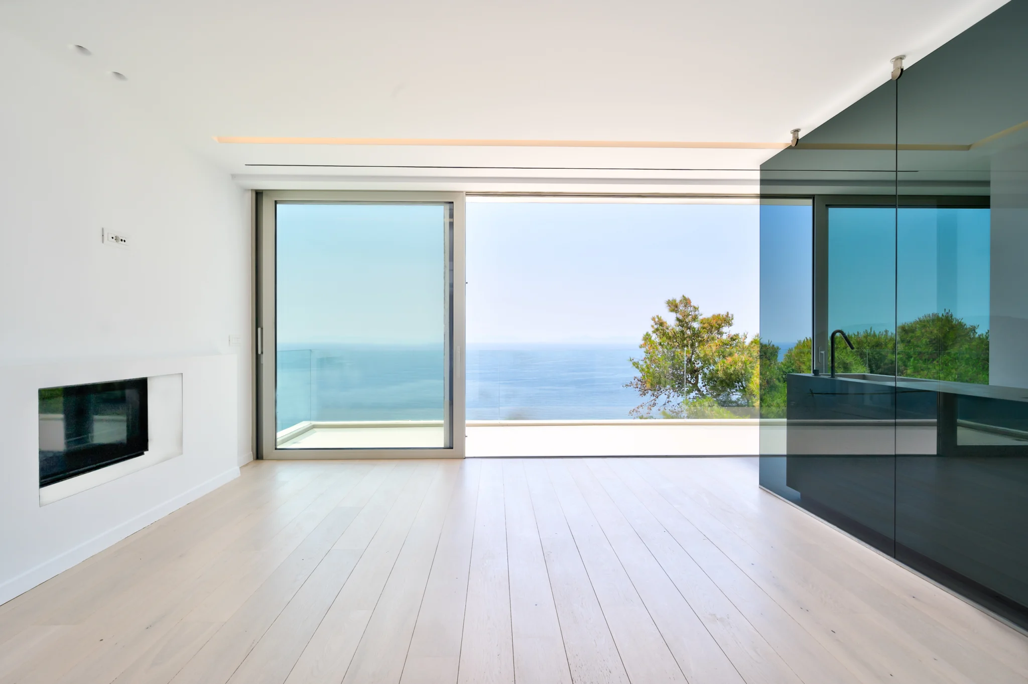 Unfurnished room with a fireplace, glass partition and sea view at Luxury Residence Blackstone.