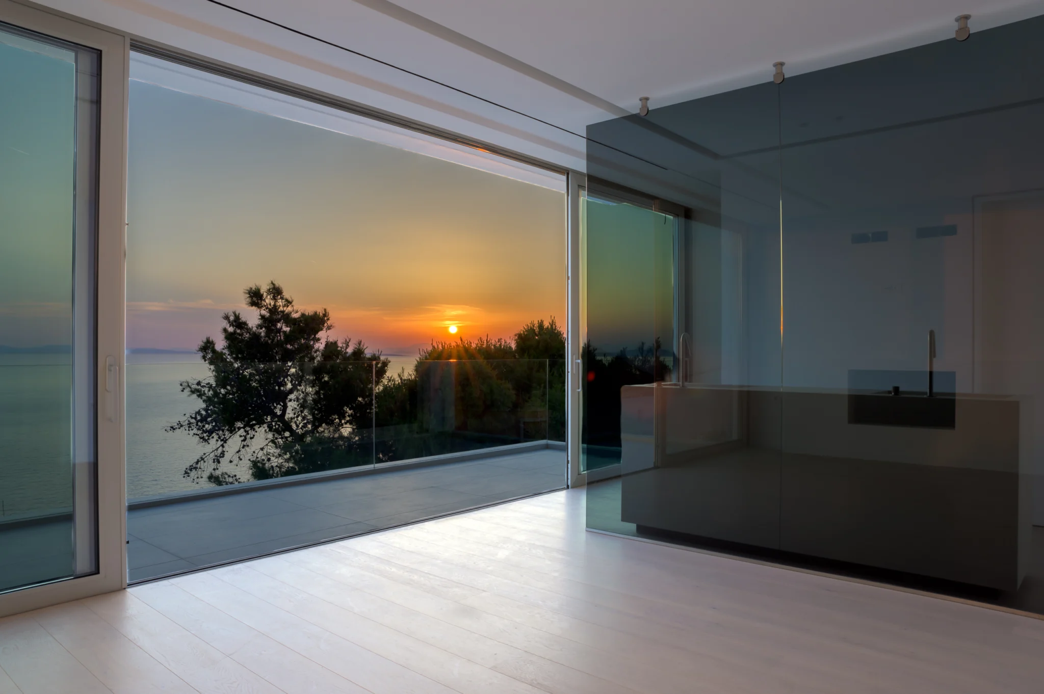 Sunset seen through glazing beside a glass partition at Luxury Residence Blackstone.