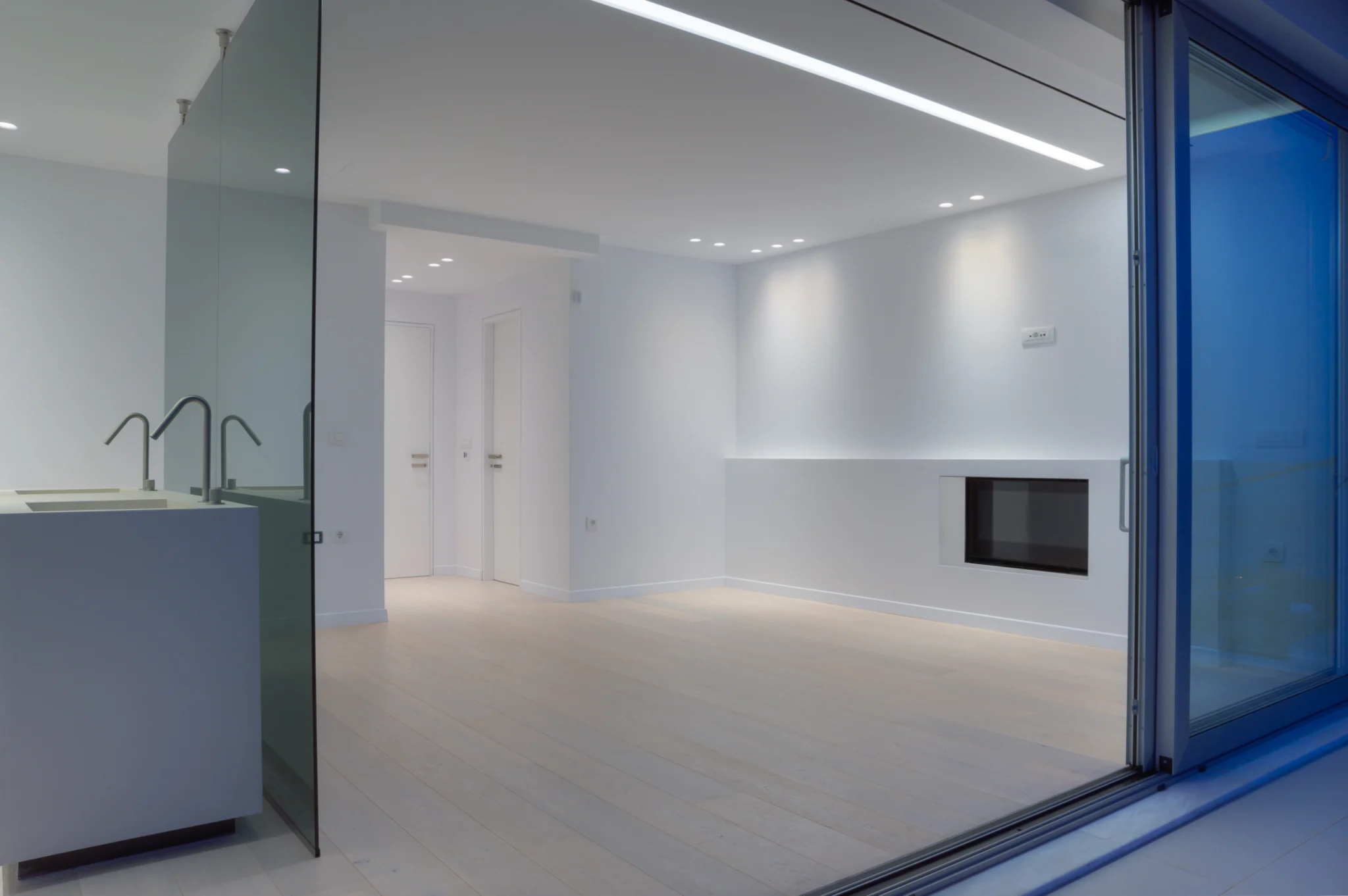 Glass partition and basin seen through exterior glazing at twilight at Luxury Residence Blackstone.