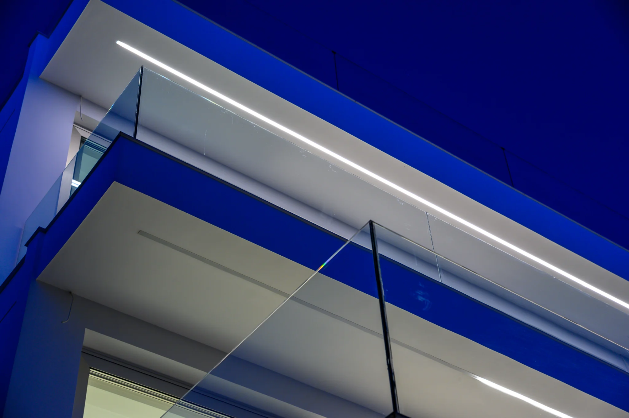 Illuminated balcony edges and glass balustrades against a deep blue sky at Luxury Residence Blackstone.