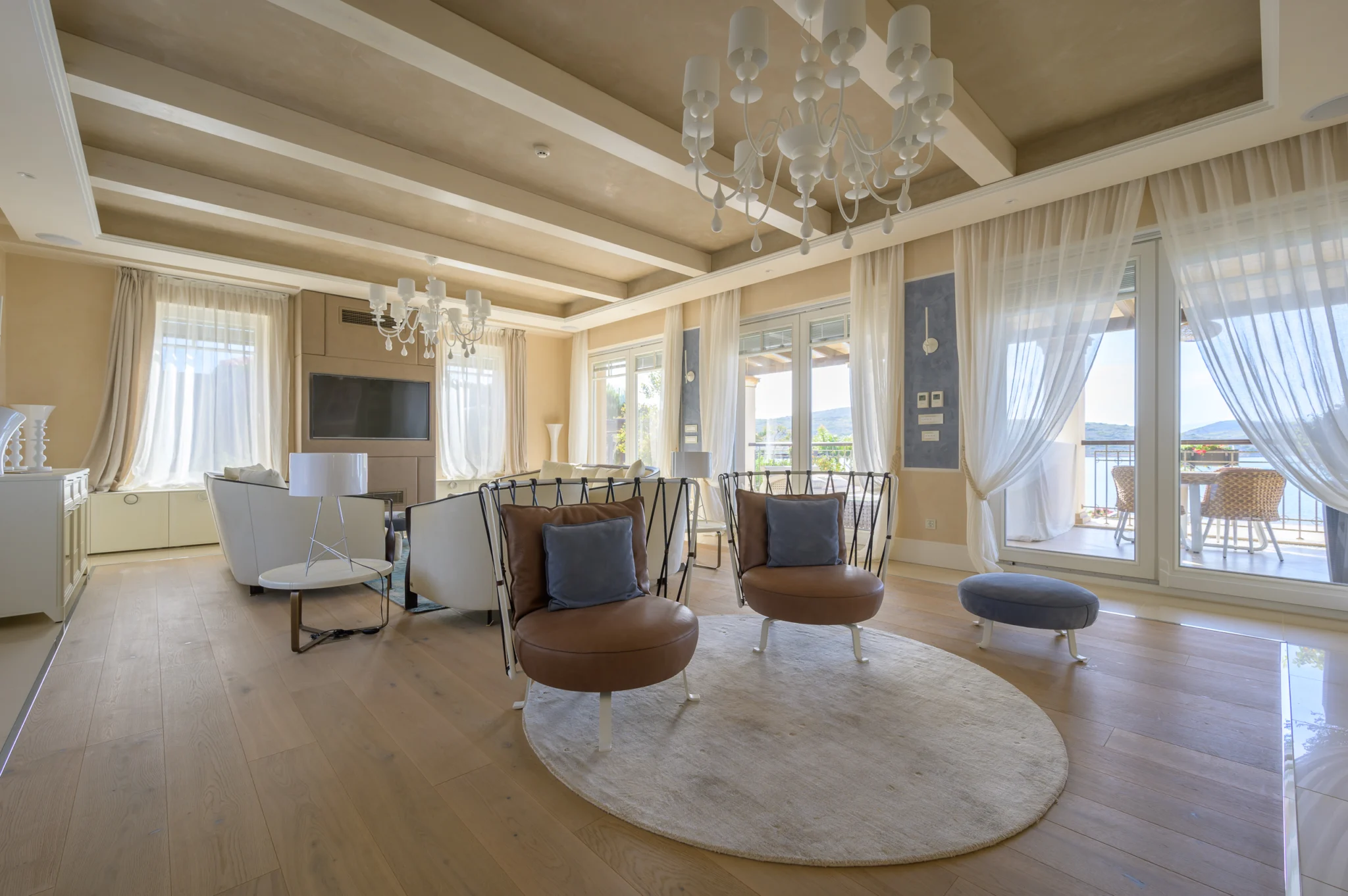 Open-plan living and dining room with panoramic windows at Mirum Villas, Crete, Greece