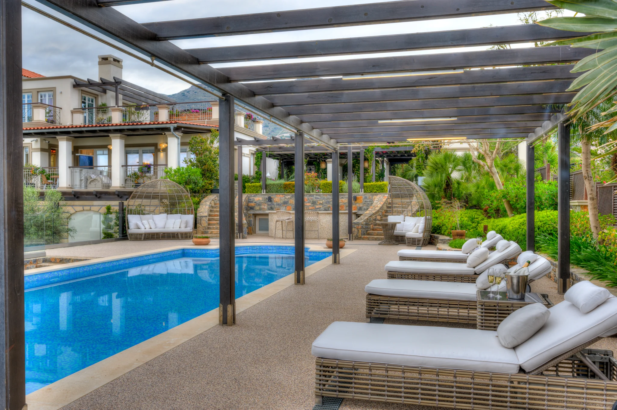 Long swimming pool beside a pergola and sun loungers at Mirum Villas, Crete, Greece