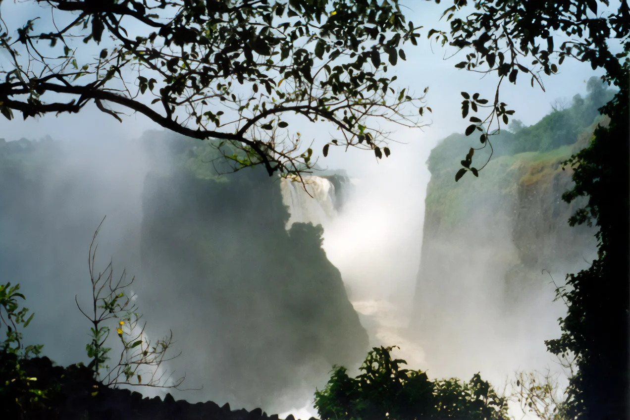 Large mist-filled waterfall framed by dark tropical vegetation