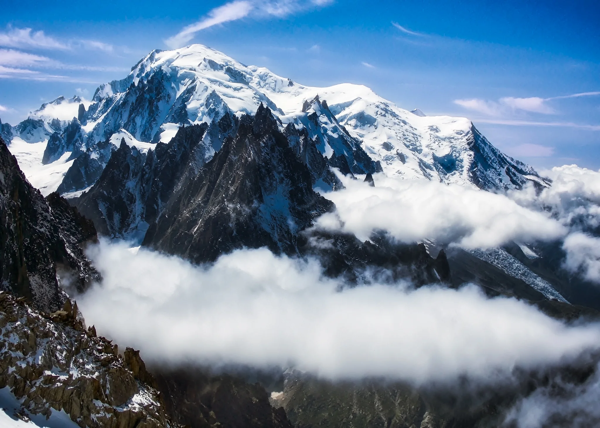 Mont Blanc massif rising above cloud and dark alpine needles in France