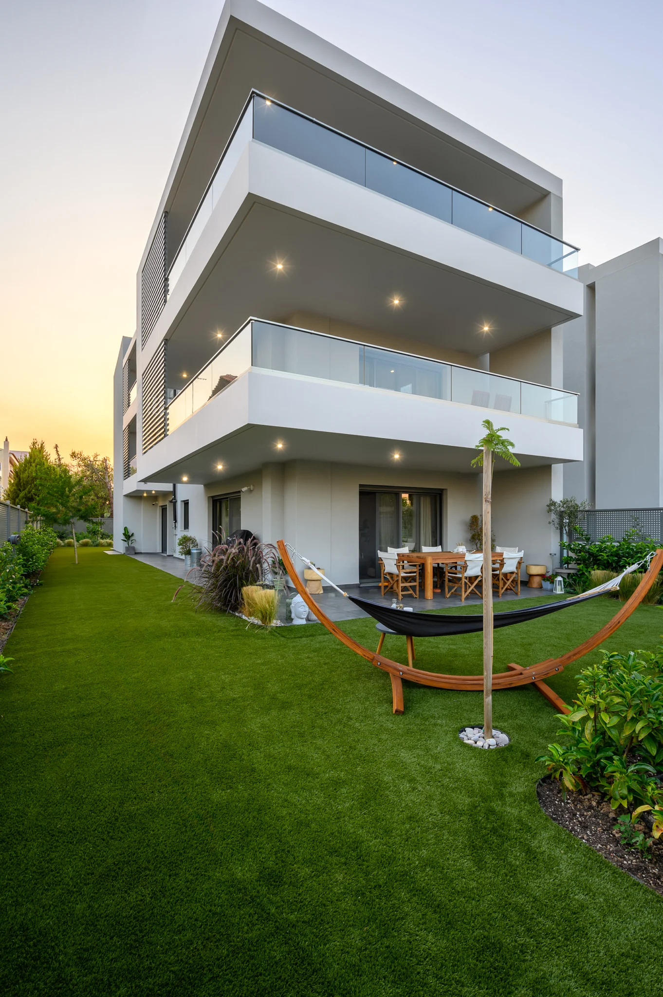 Lawn and hammock below projecting glass balconies at Residential Complex in Athens, Athens, Attica, Greece.