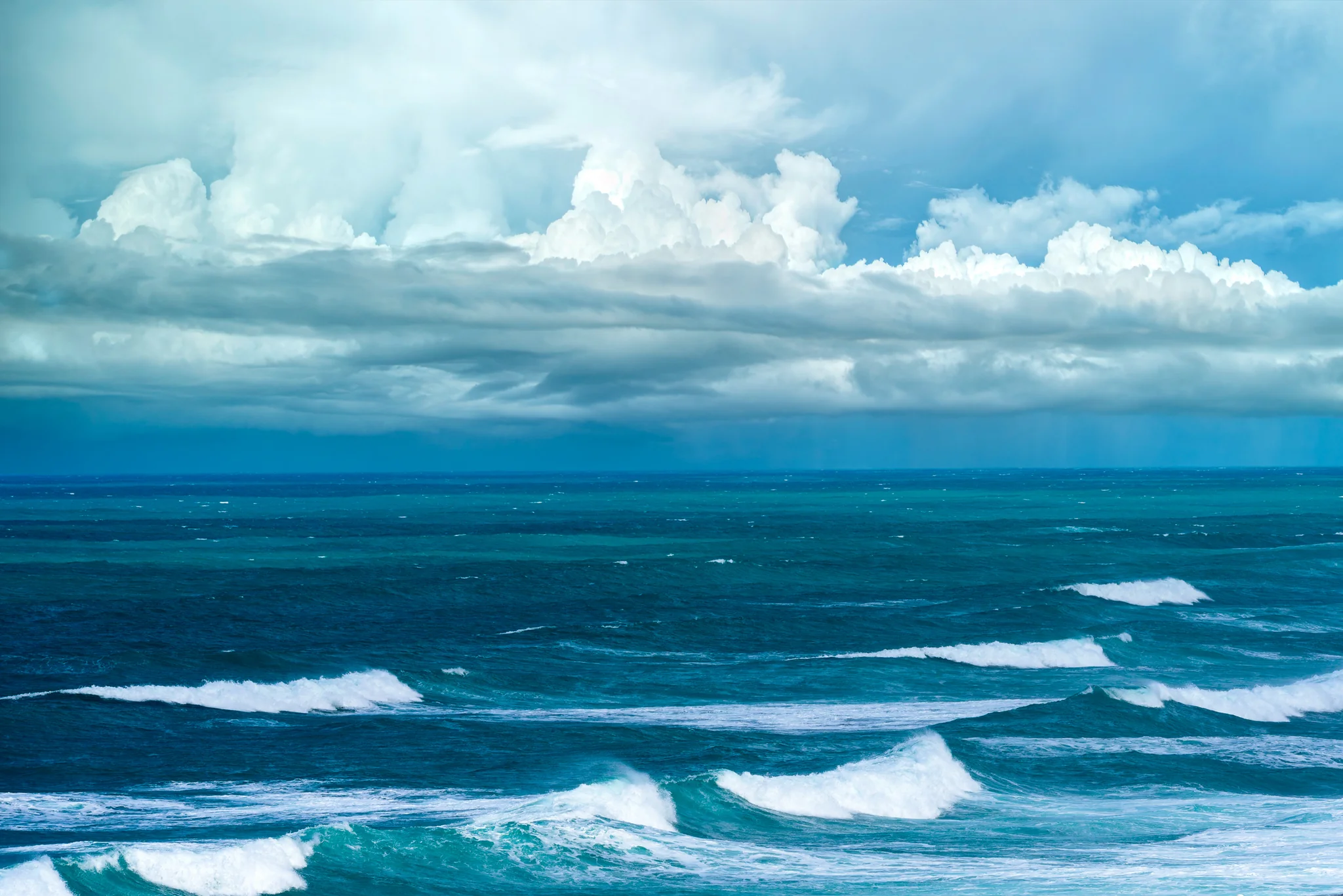 Rough open sea beneath towering dark storm clouds