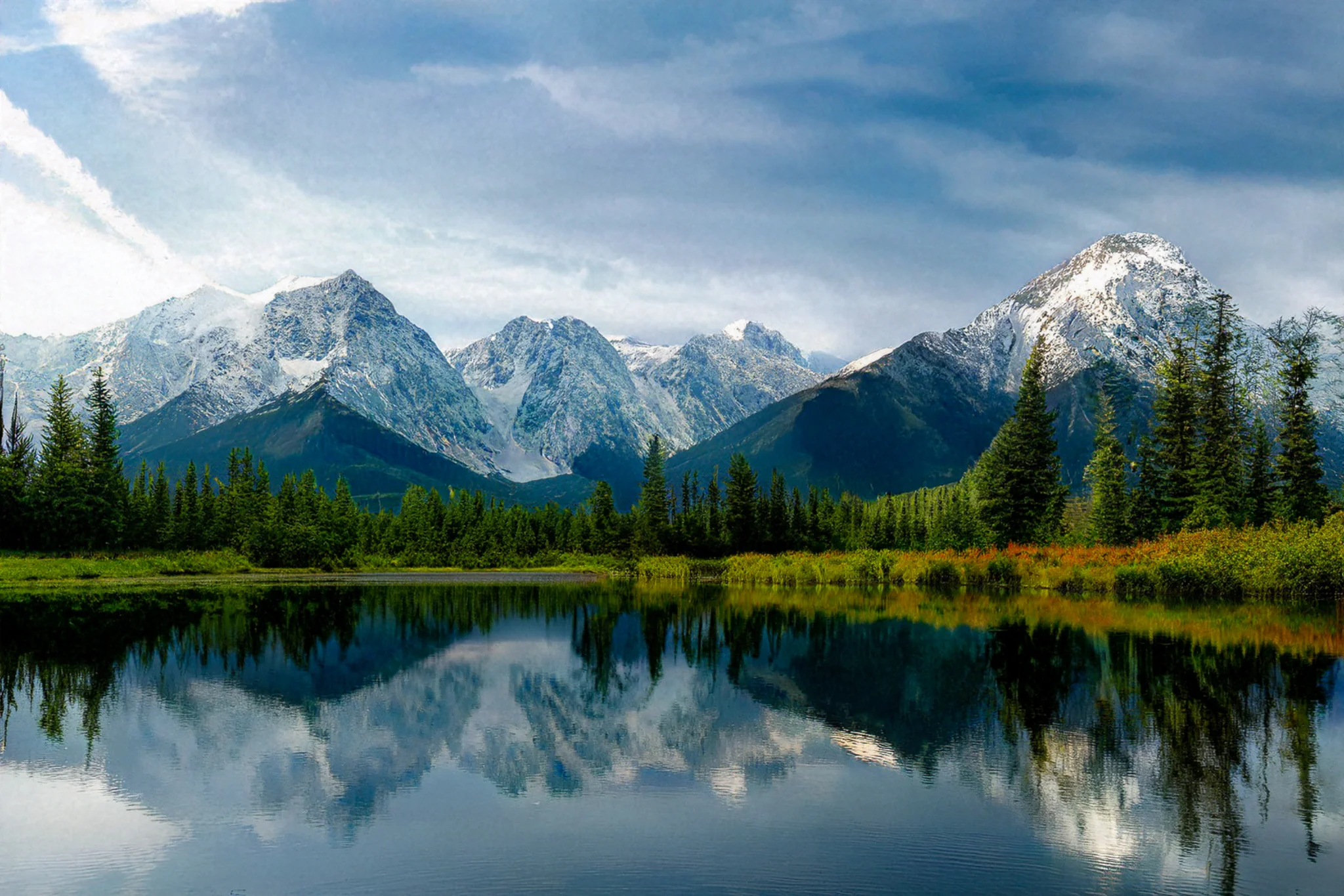 Snow-tipped alpine peaks reflected in a still forest lake