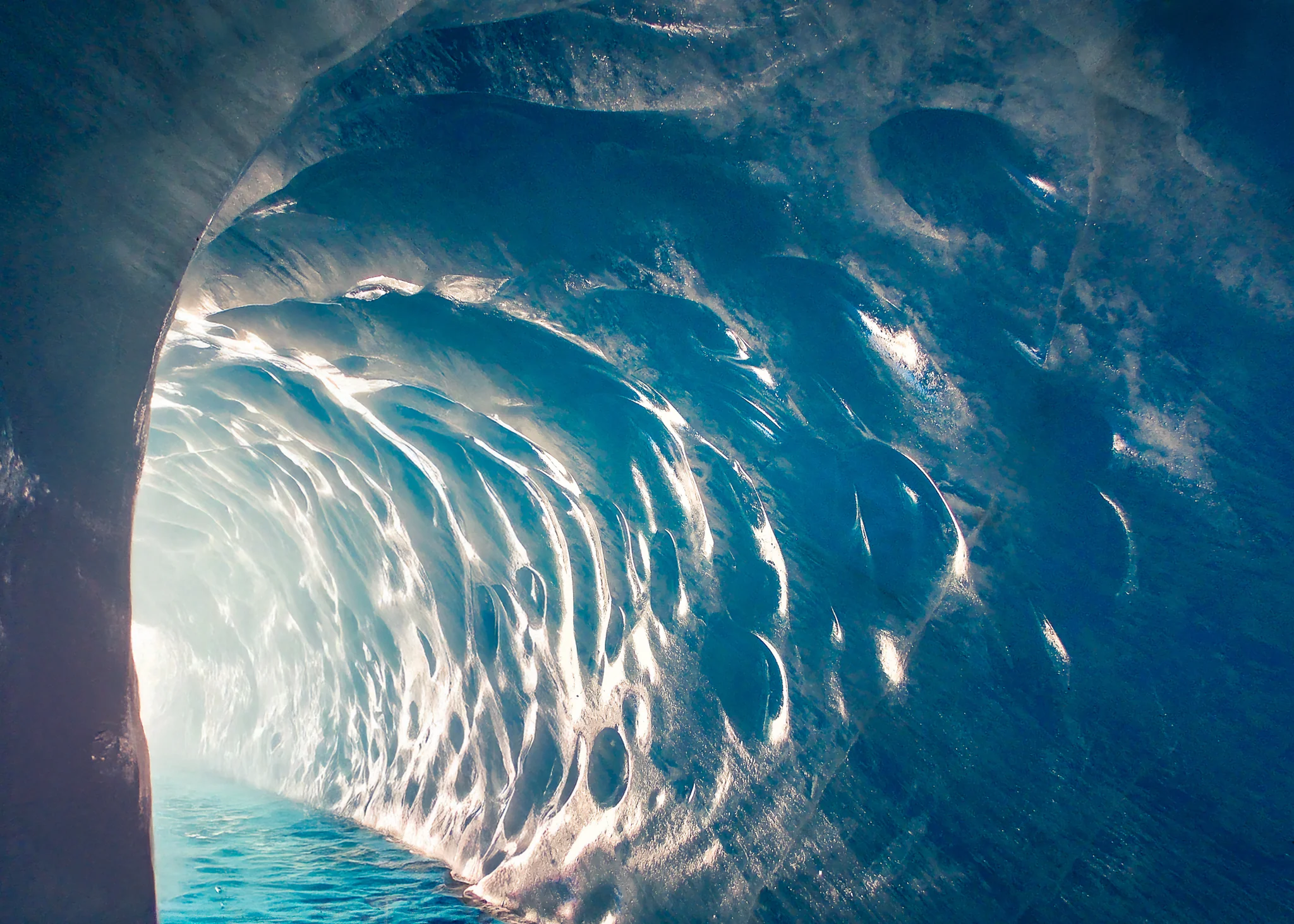 Curving translucent blue walls inside an ice cave