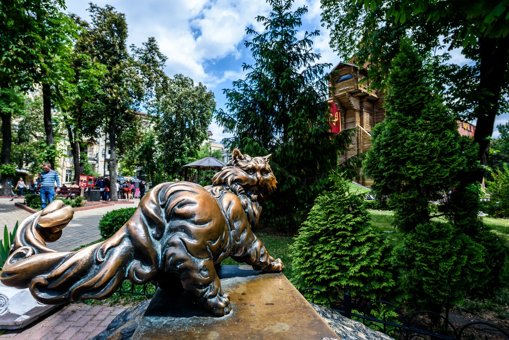 Bronze animal sculptures arranged along a shaded city park path