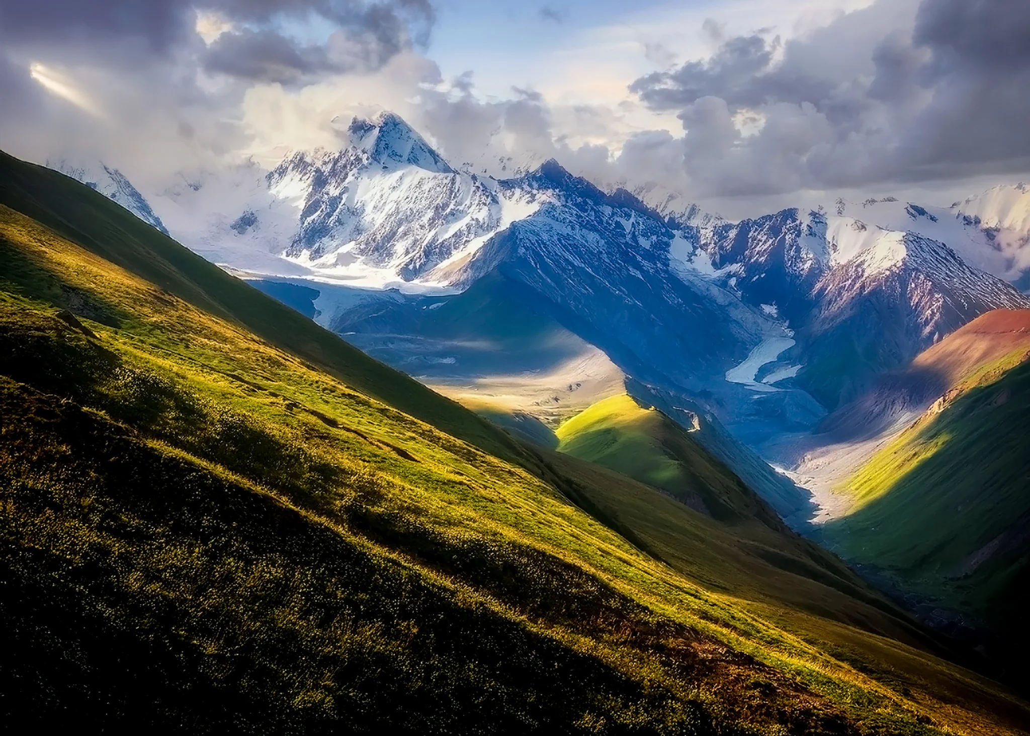 Caucasus Mountains in Georgia Sunlit green slopes leading toward the Caucasus Mountains in Georgia