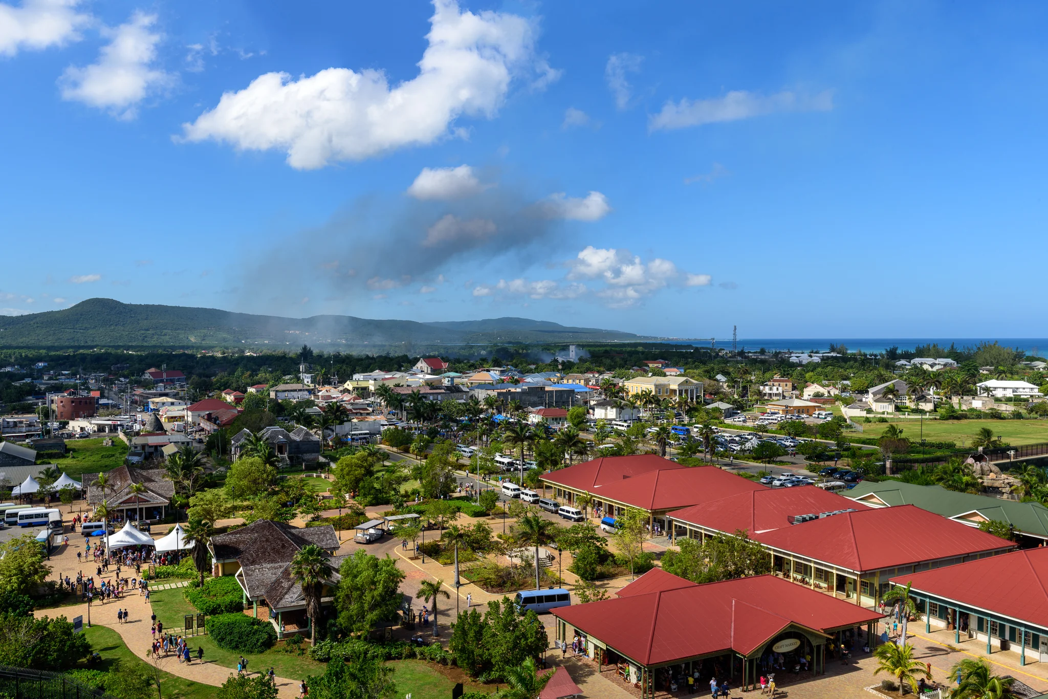 Elevated panorama of a low coastal town beneath scattered clouds
