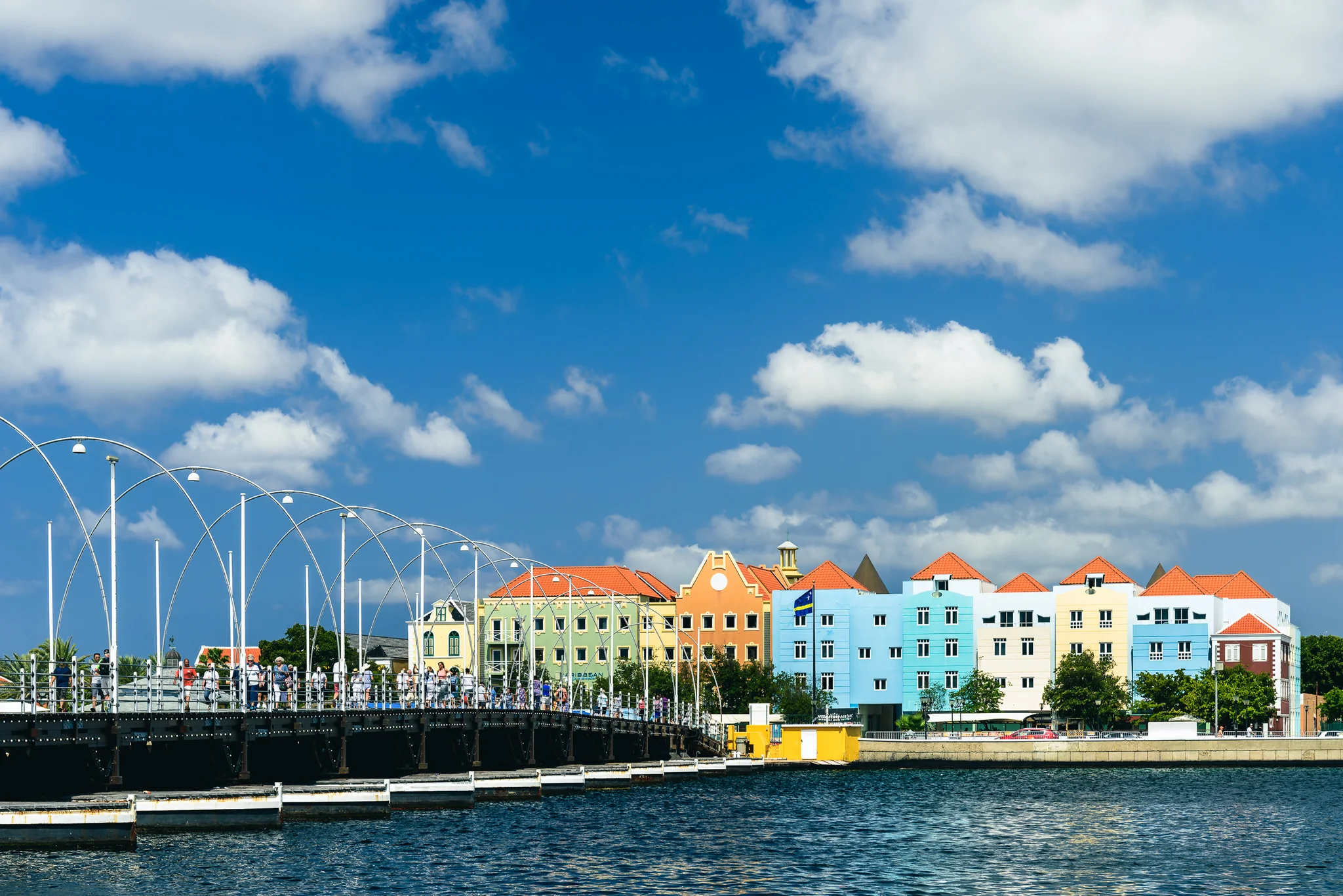Colourful gabled waterfront buildings beside a modern bridge