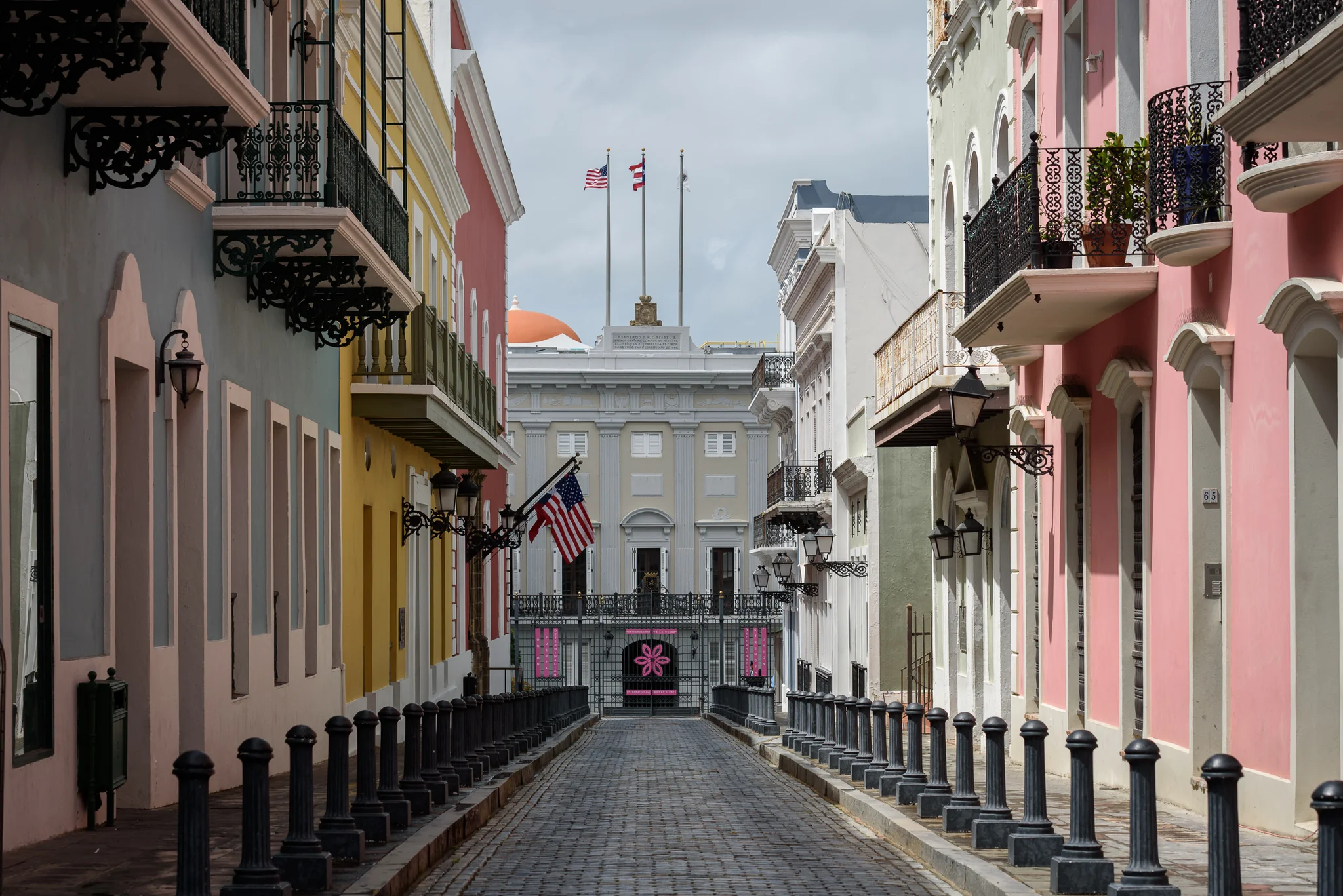 Narrow street lined with pastel colonial buildings and balconies