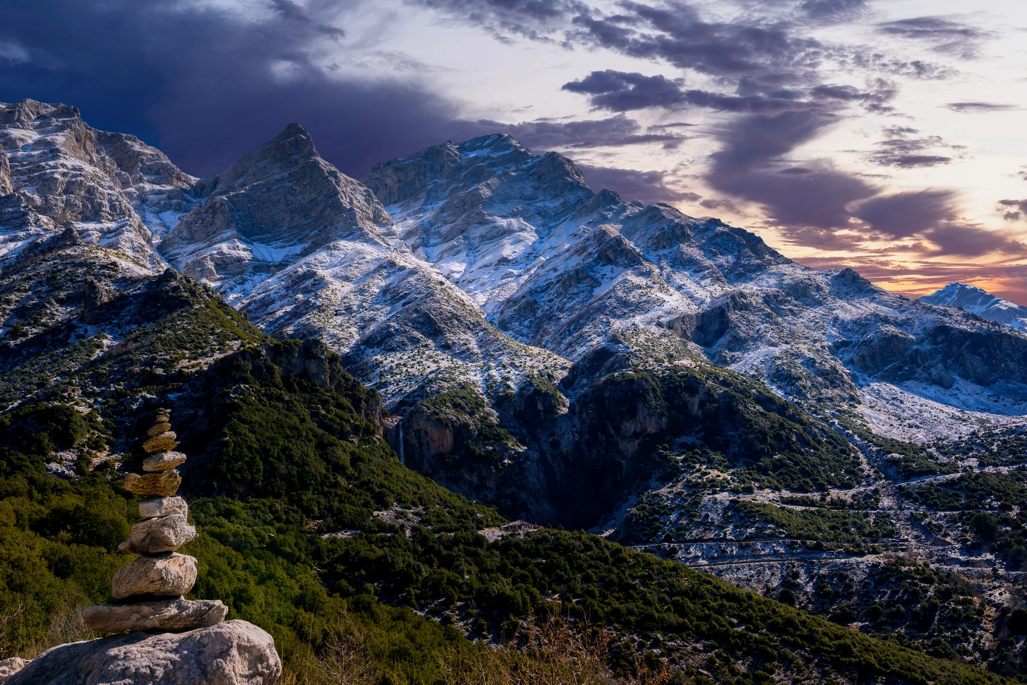 Snow-covered mountain range under soft evening cloud