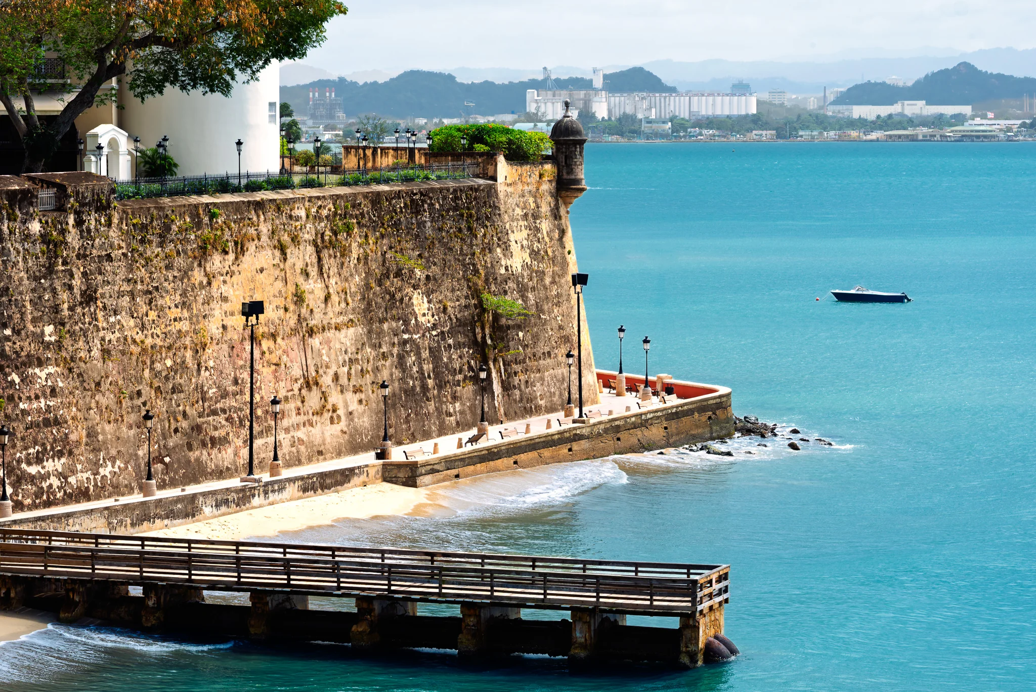 Historic stone seawall and timber pier beside turquoise harbor water