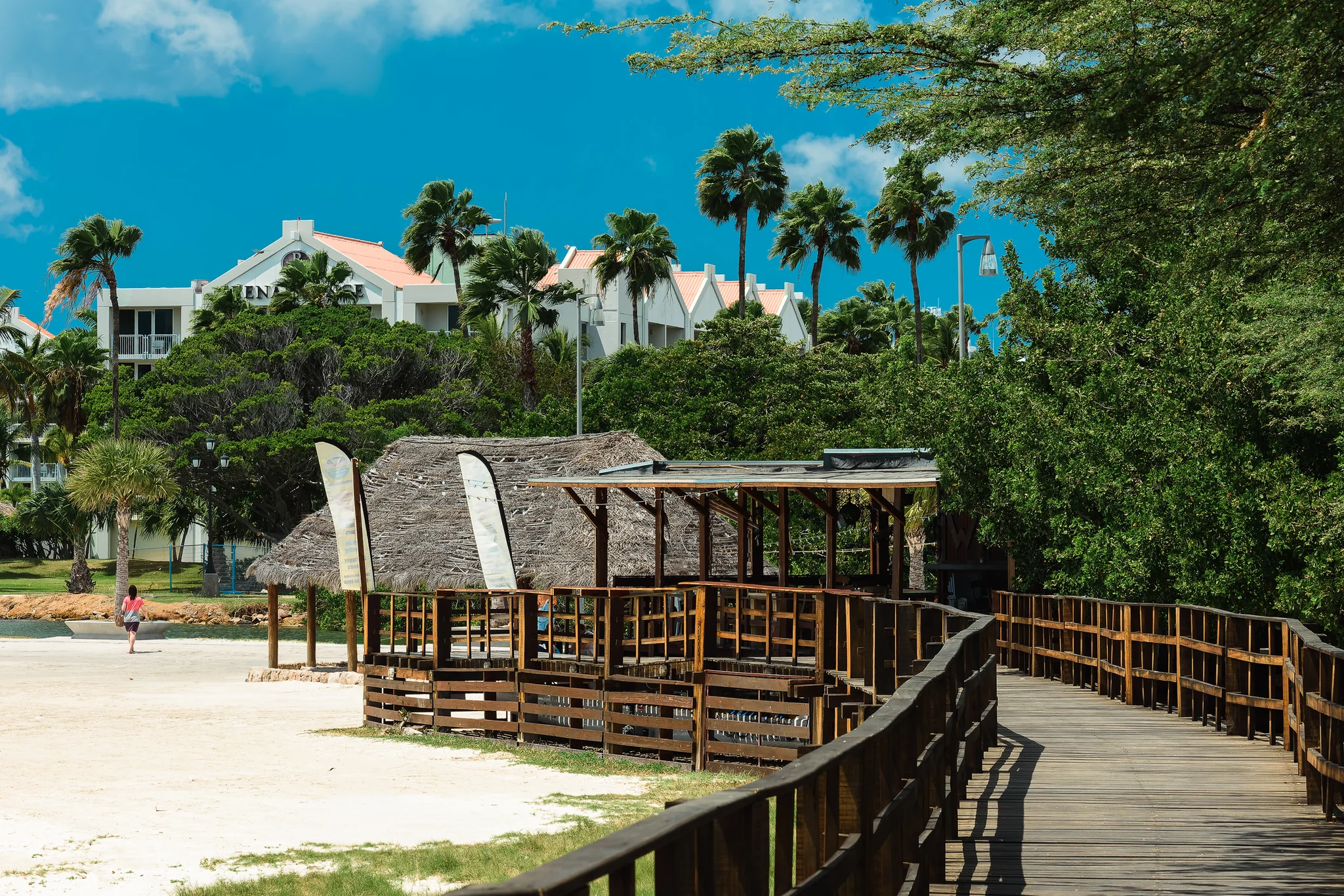 Timber boardwalk leading through a tropical beachfront resort