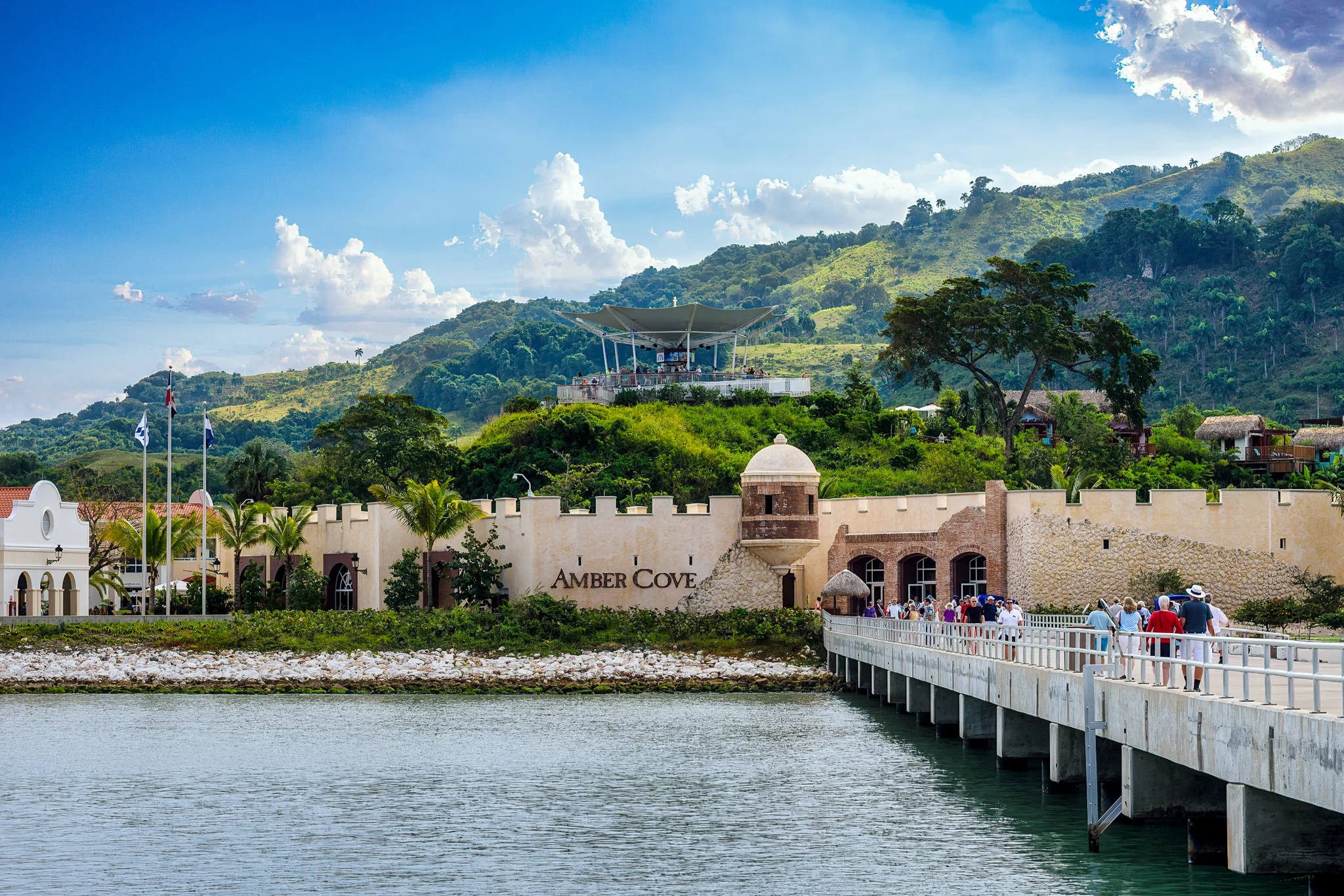 Waterfront resort buildings and a long pier beside calm water