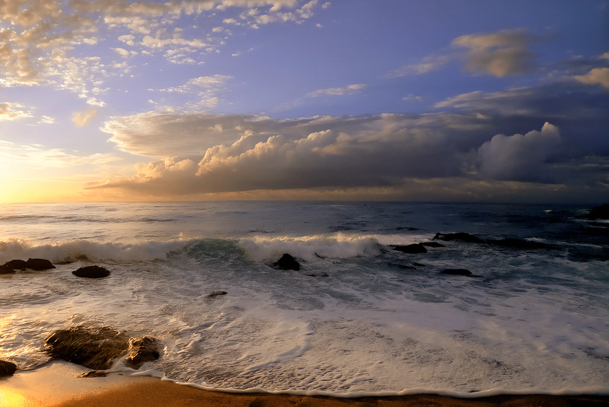 Powerful surf breaking on a rocky beach beneath storm clouds in the United States