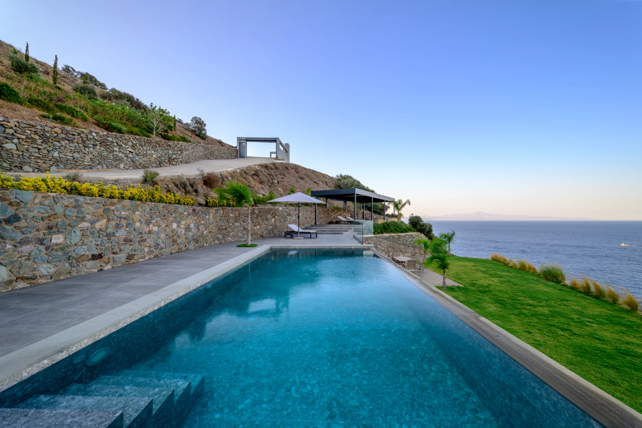 Swimming pool and stone terrace overlooking the sea at Villa in Athens, Athens, Attica, Greece.