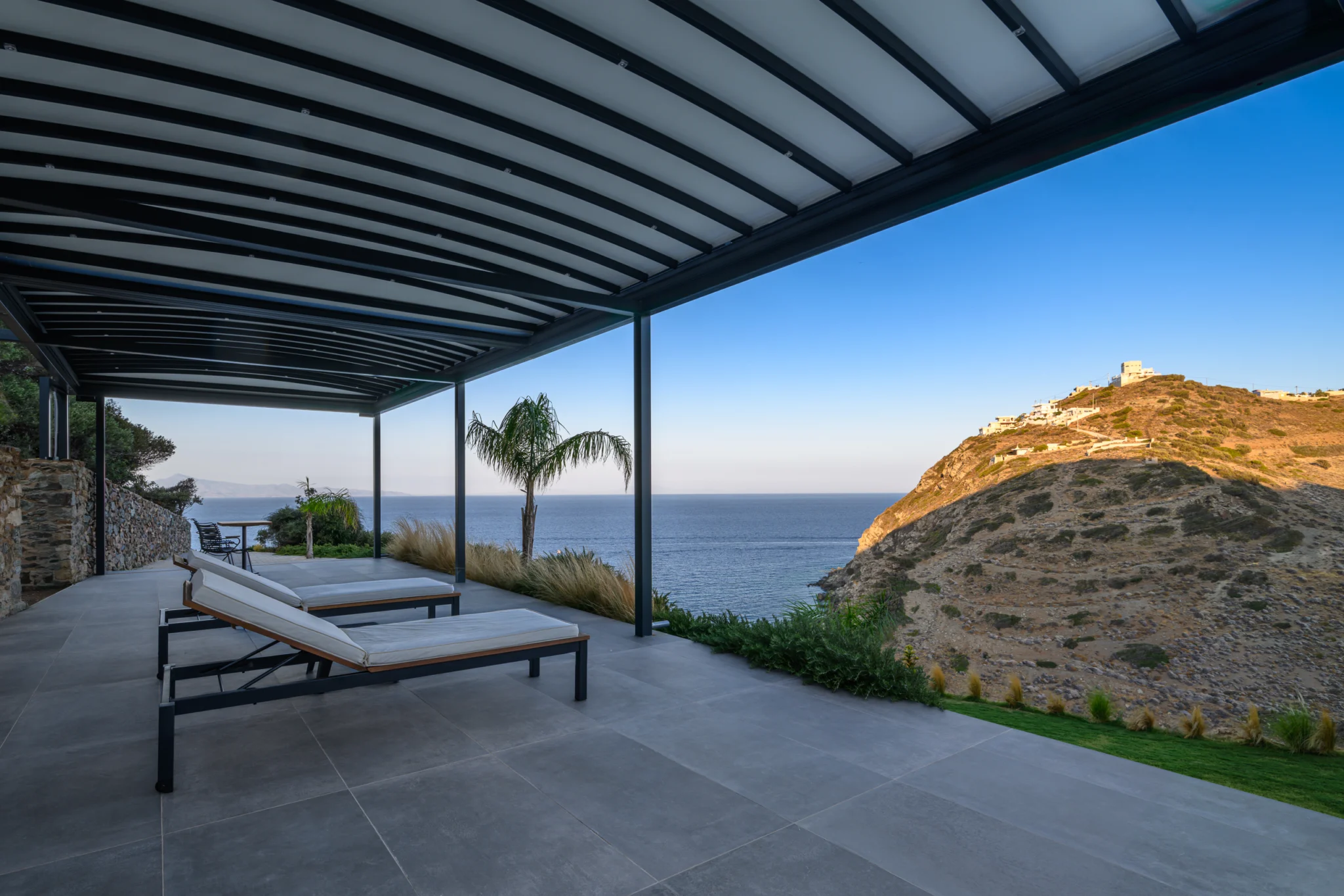 Shaded terrace with loungers overlooking the coast at Villa in Athens, Athens, Attica, Greece.