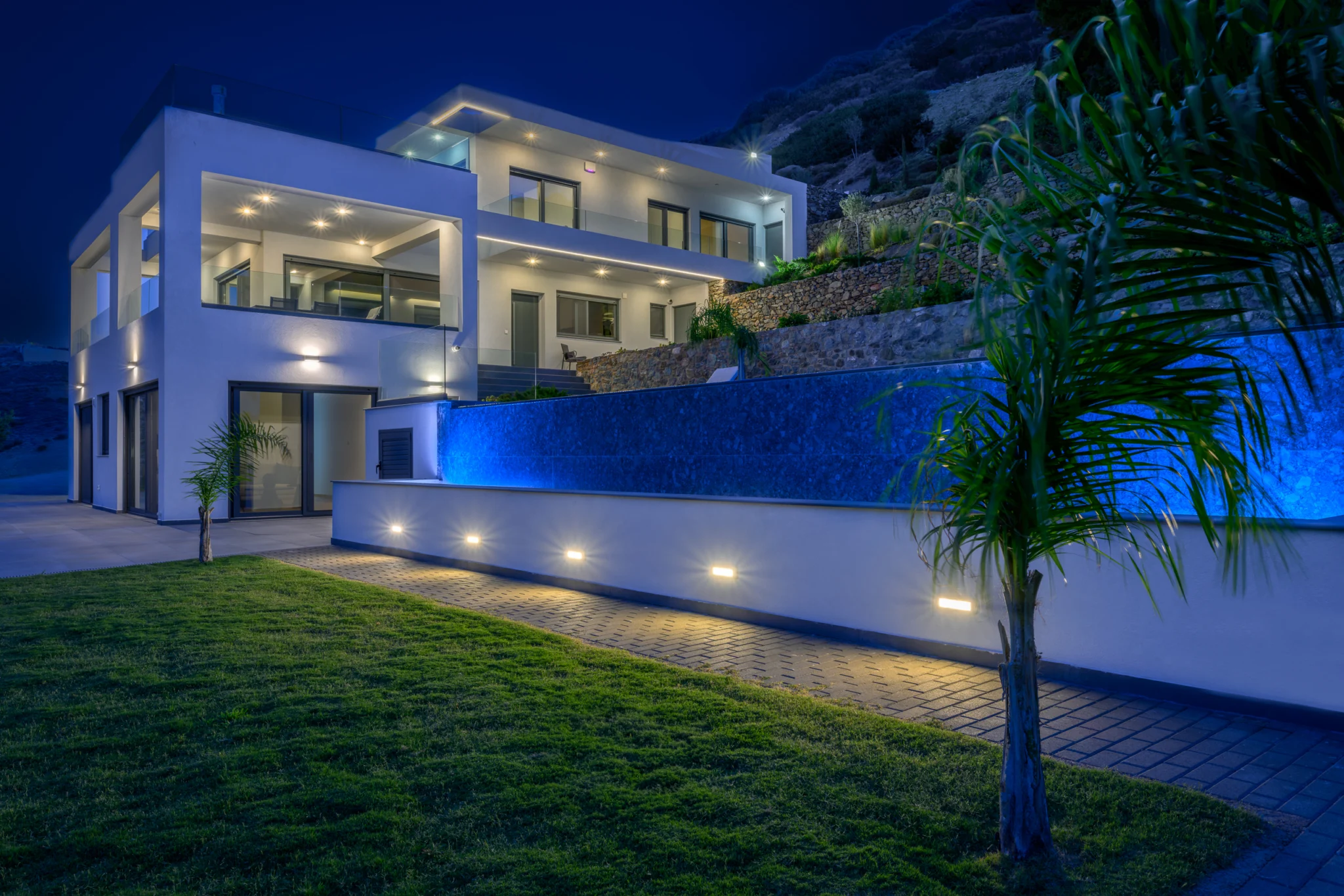 Illuminated villa, pool and garden lawn at night at Villa in Athens, Athens, Attica, Greece.