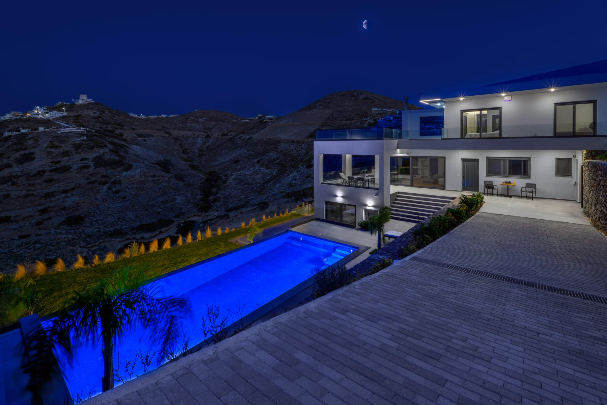 Illuminated pool and villa viewed from an upper terrace at night at Villa in Athens, Athens, Attica, Greece.