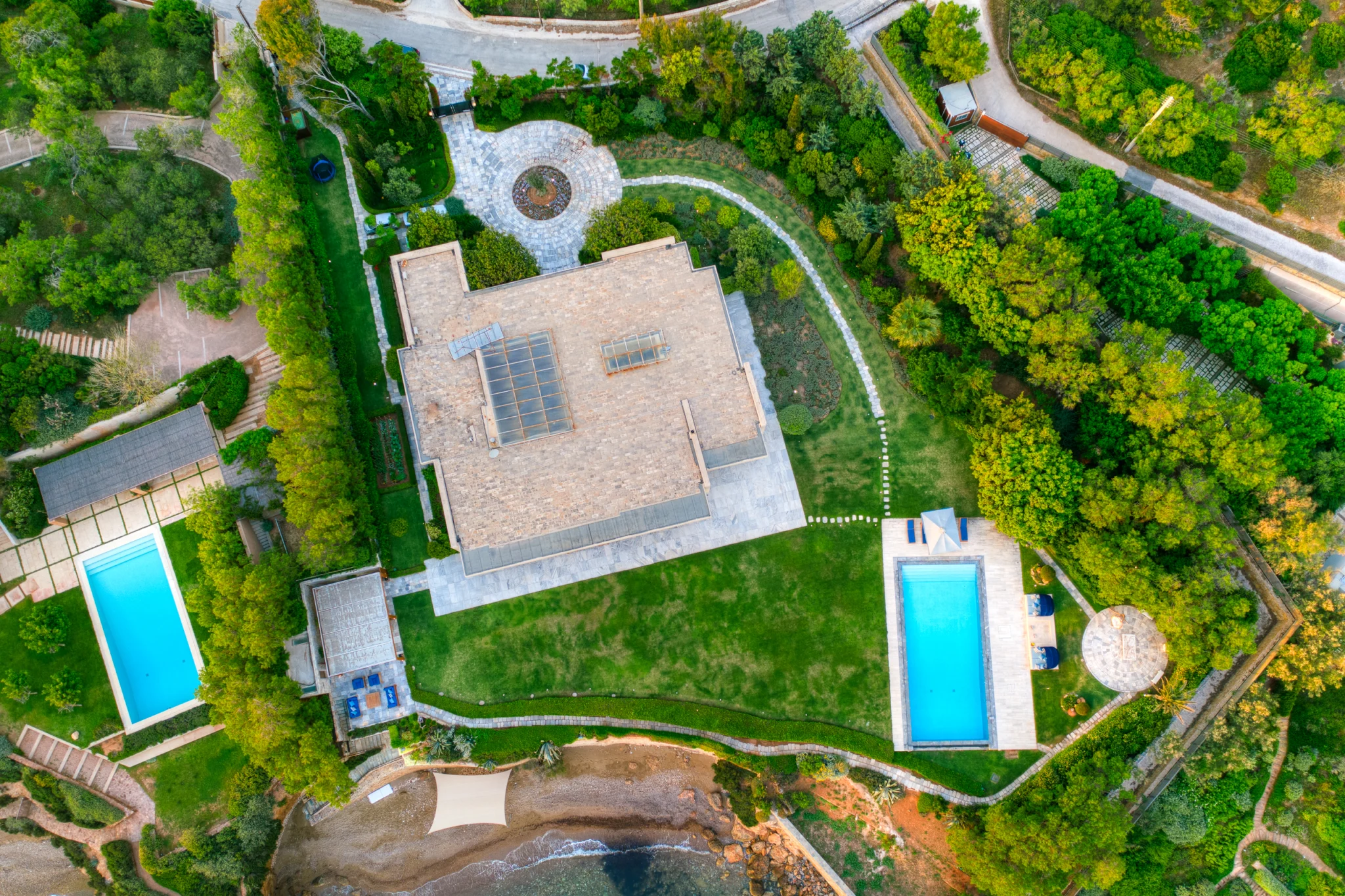 Overhead view of the villa roof, lawn, pool and shoreline at Villa Icarus.