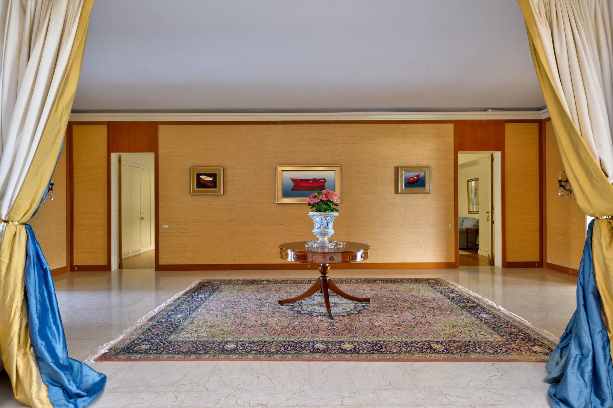 Reception area with a round table and blue curtains seen through a wide doorway at Villa Icarus.